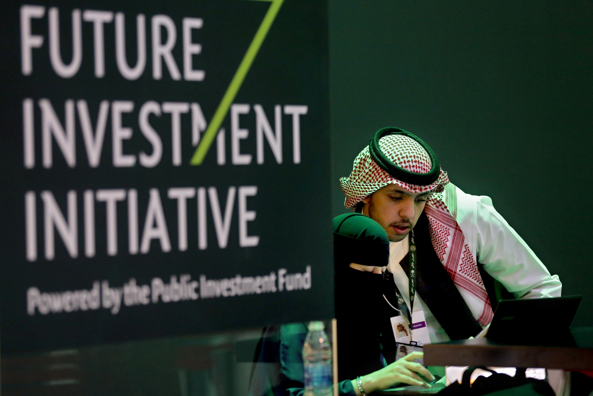 Saudi employees print badges of participants of the Future Investment Initiative conference set to start October 23 in Riyadh, Saudi Arabia, Oct. 22 (AP Photo/Amr Nabil)