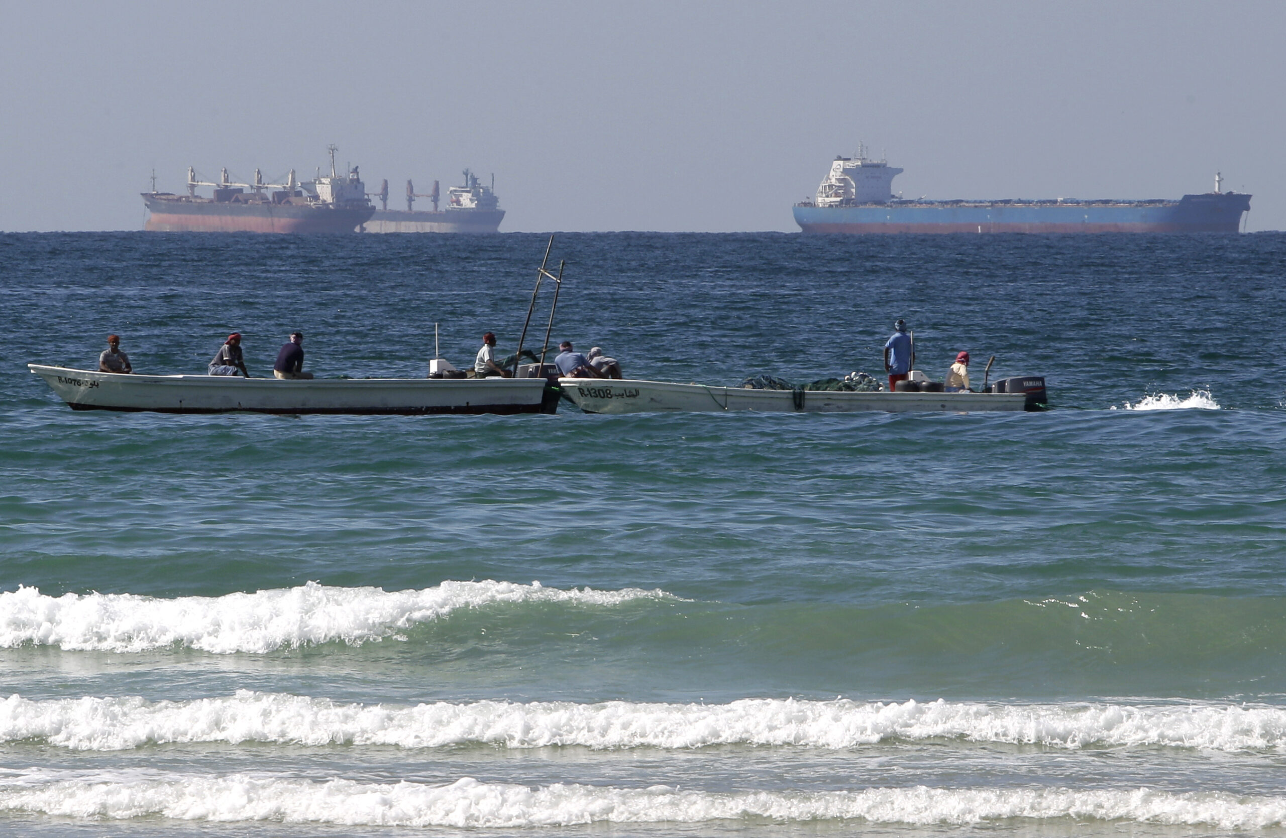 Fishing boats are seen in front of oil tankers south of the Strait of Hormuz, offshore the emirate of Ras Al Khaimah, United Arab Emirates. (AP Photo/Kamran Jebreili)