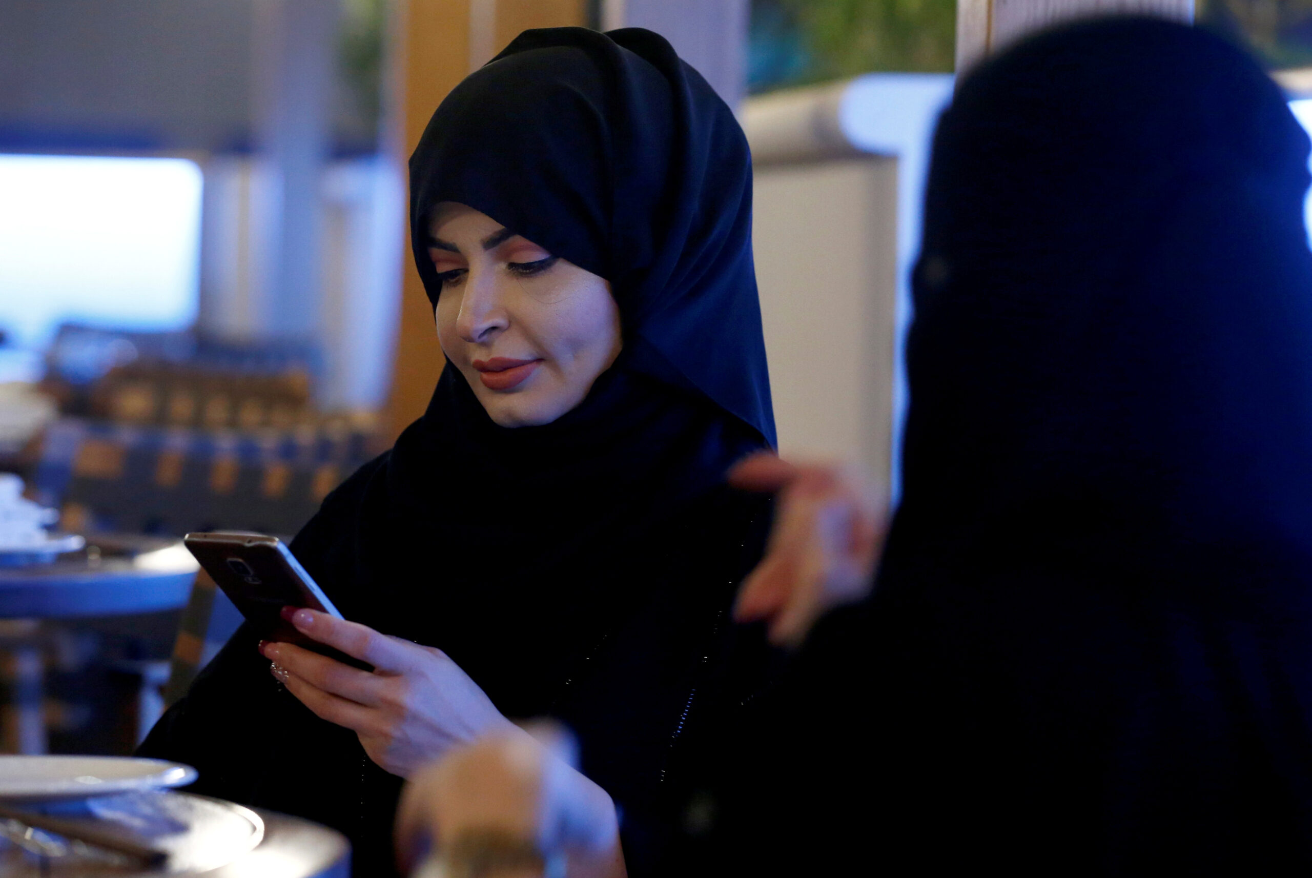 A woman uses her phone in a cafe in Riyadh, Saudi Arabia (REUTERS/Faisal Al Nasser)