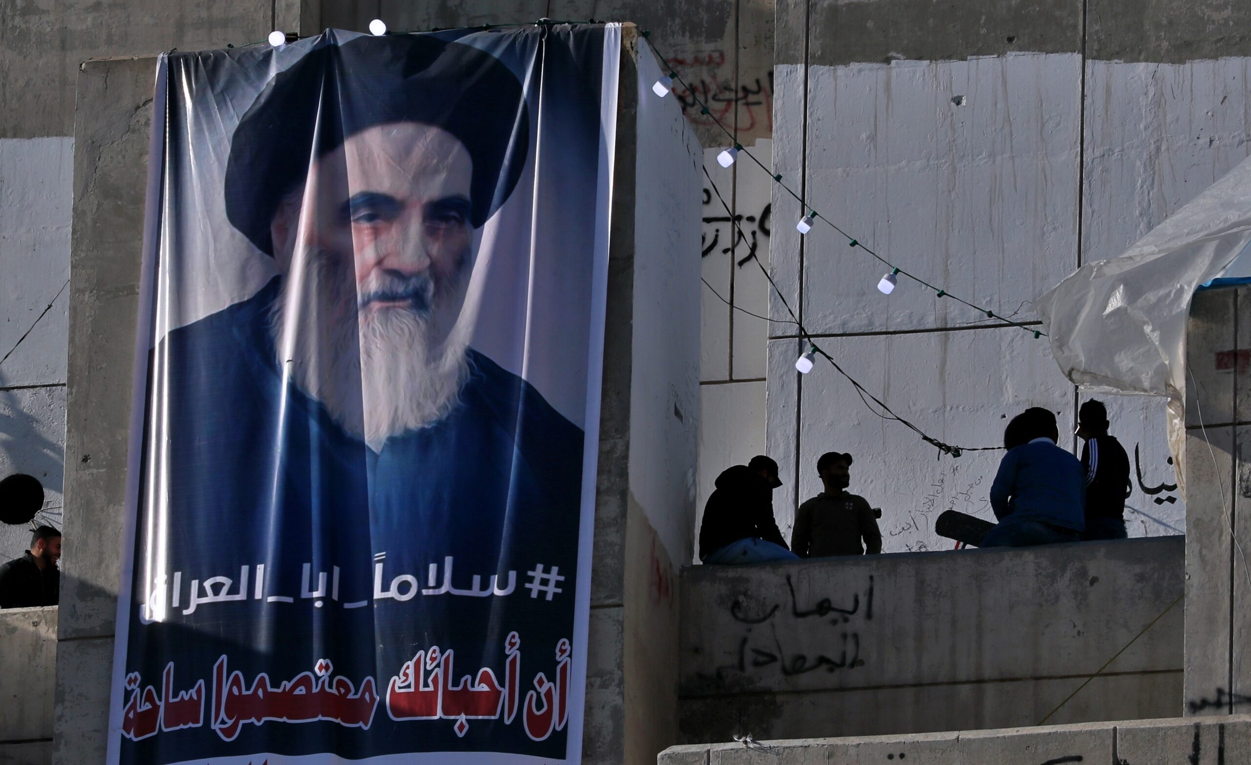 A poster of Grand Ayatollah Ali Sistani on display reads, "Peace, father of Iraq," in Tahrir Square, Baghdad, Iraq, Feb. 1, 2020. (AP Photo/Khalid Mohammed)