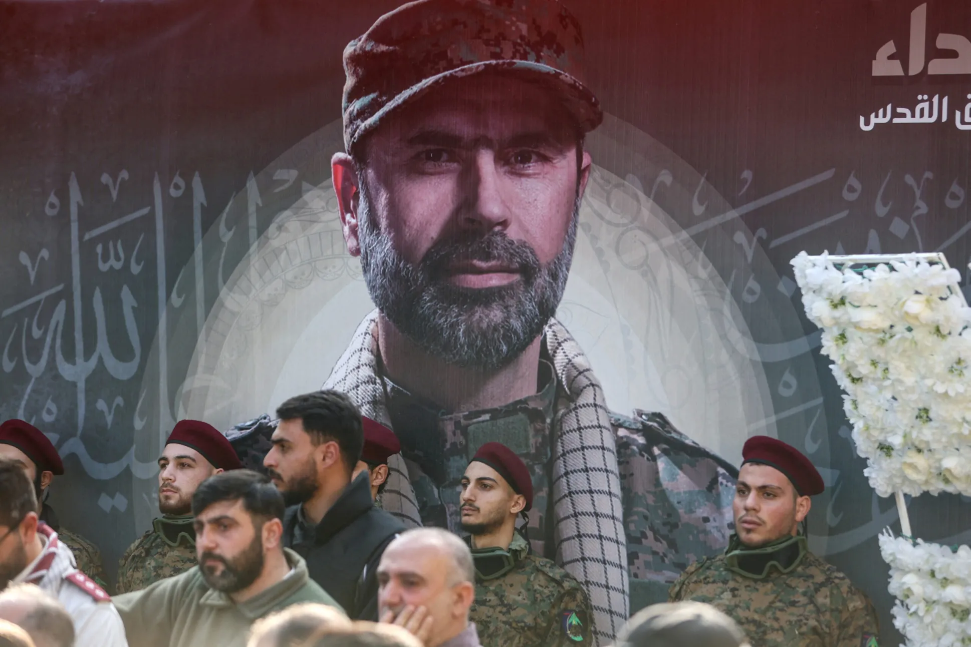 Members of Hezbollah stand next to a banner depicting Wissam Hassan al-Tawil, a commander of Hezbollah's elite Radwan forces, during his funeral, in Khirbet Silem, Lebanon, January 9. (REUTERS/Aziz Taher)