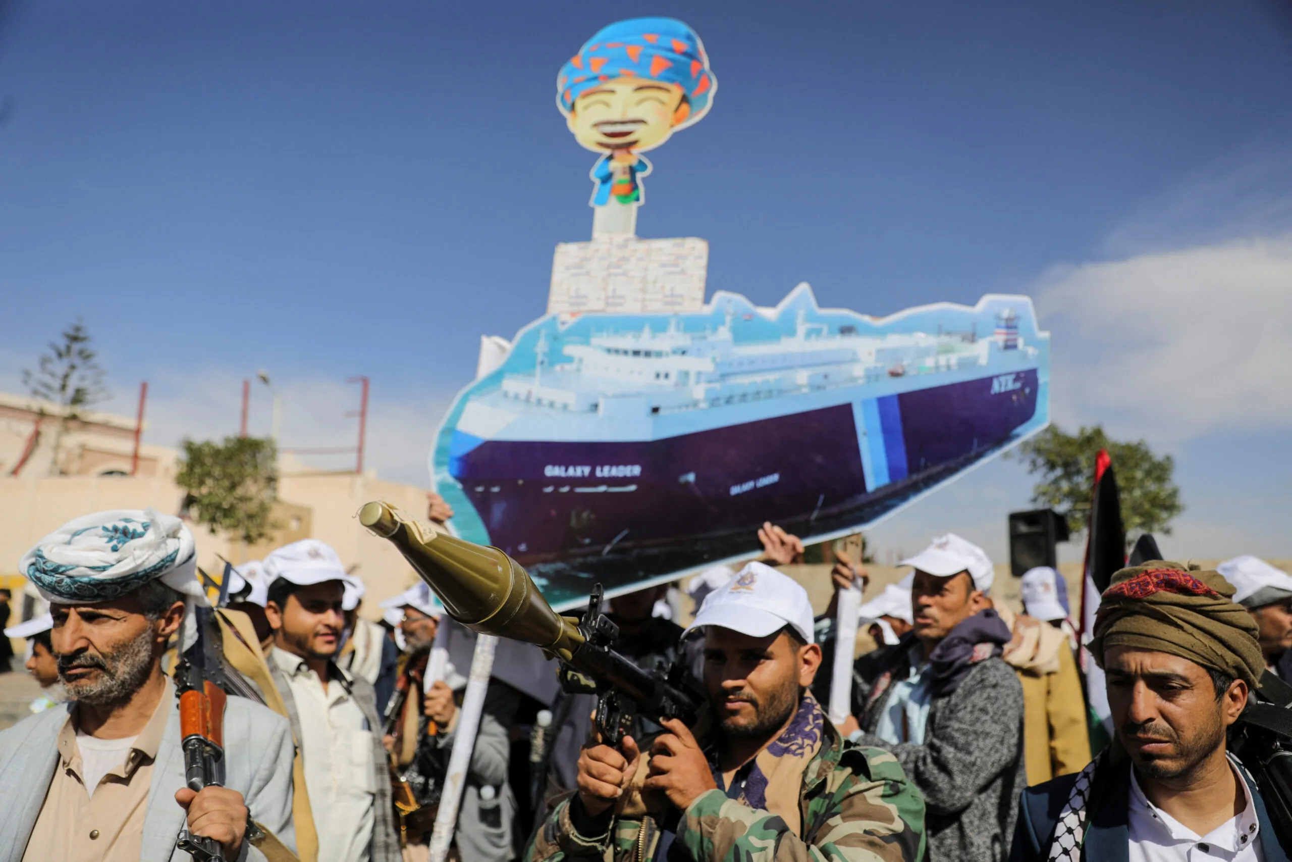 Houthi followers hold a cutout banner portraying the Galaxy Leader cargo ship, which was seized by Houthis, during a parade as part of a "popular army" mobilization campaign by the movement, in Sanaa, Yemen, February 7. (REUTERS/Khaled Abdullah)