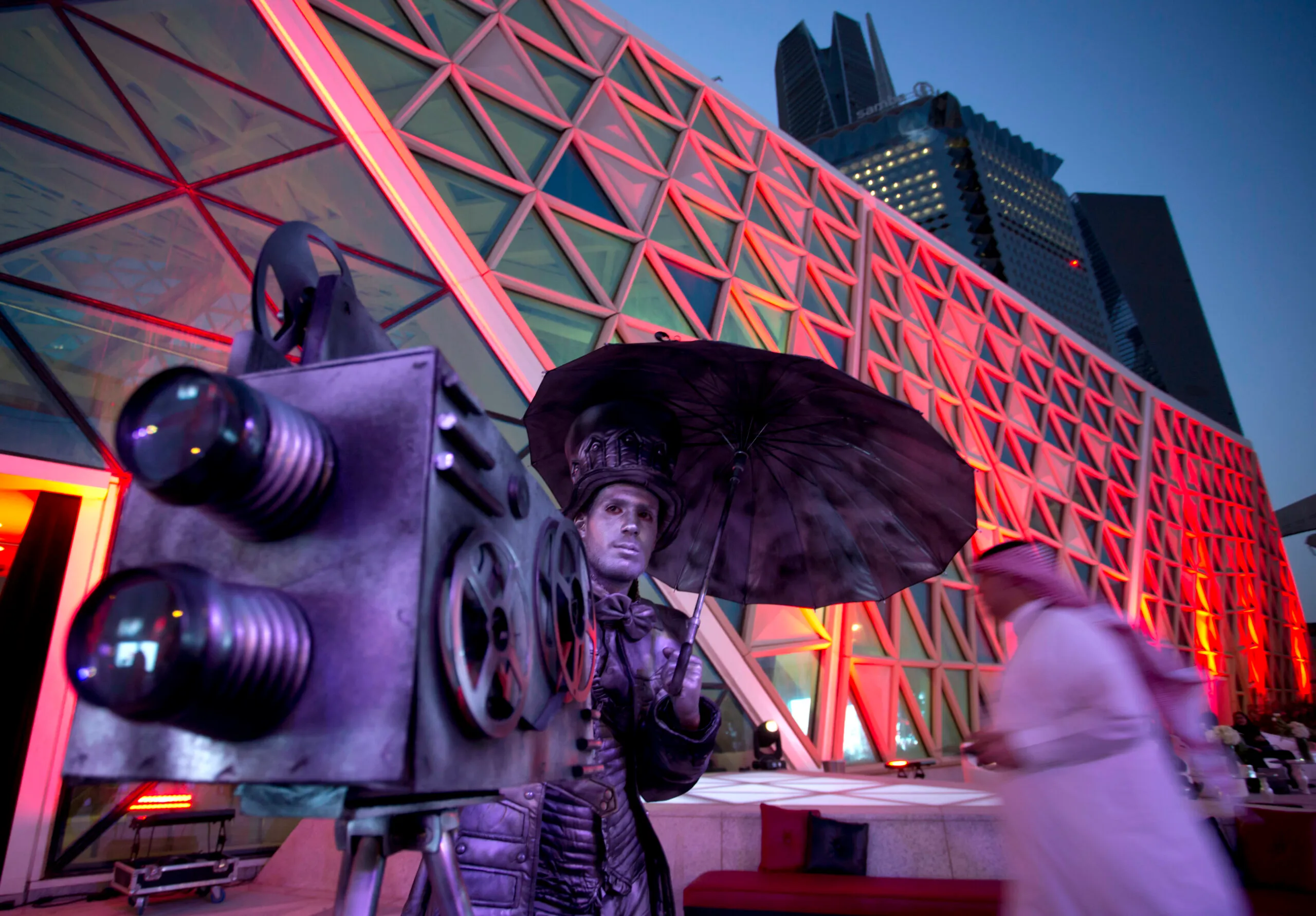 An actor poses with a replica of a vintage cinema camera as visitors enter an invitation-only screening, at the King Abdullah Financial District Theater, in Riyadh, Saudi Arabia, April 18, 2018. (AP Photo/Amr Nabil)