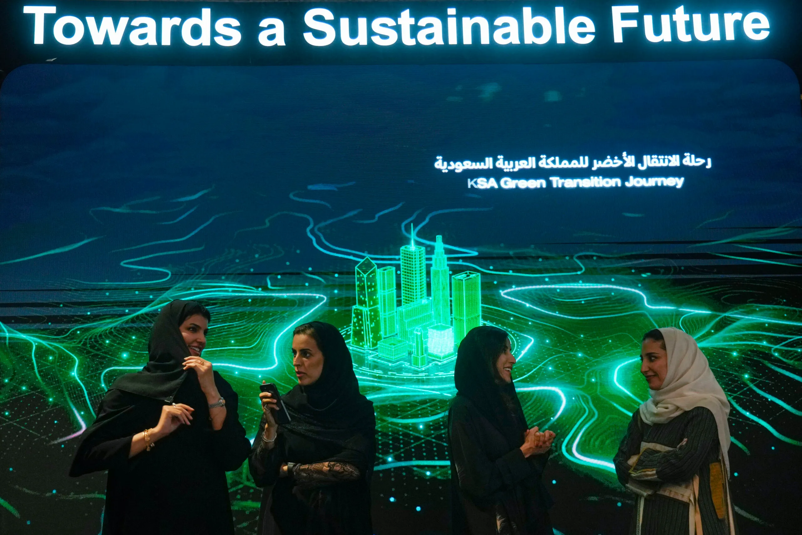 Saudi women stand at the "KSA Green Transmission Journey" exhibition marking the Security and Development Summit in Jeddah, Saudi Arabia, July 16, 2022. (AP Photo/Amr Nabil)