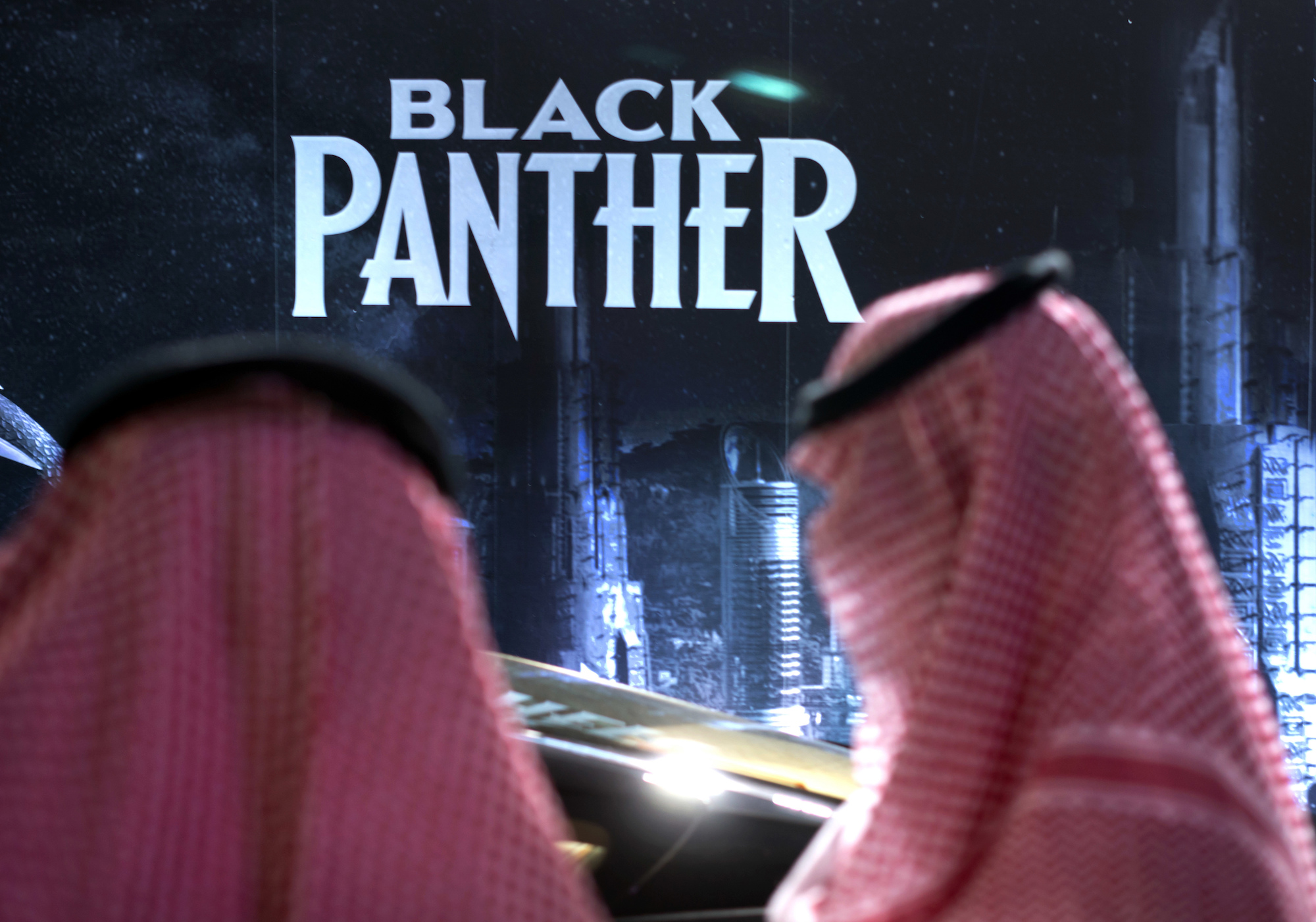 Saudis stand in front of banner for 'Black Panther'