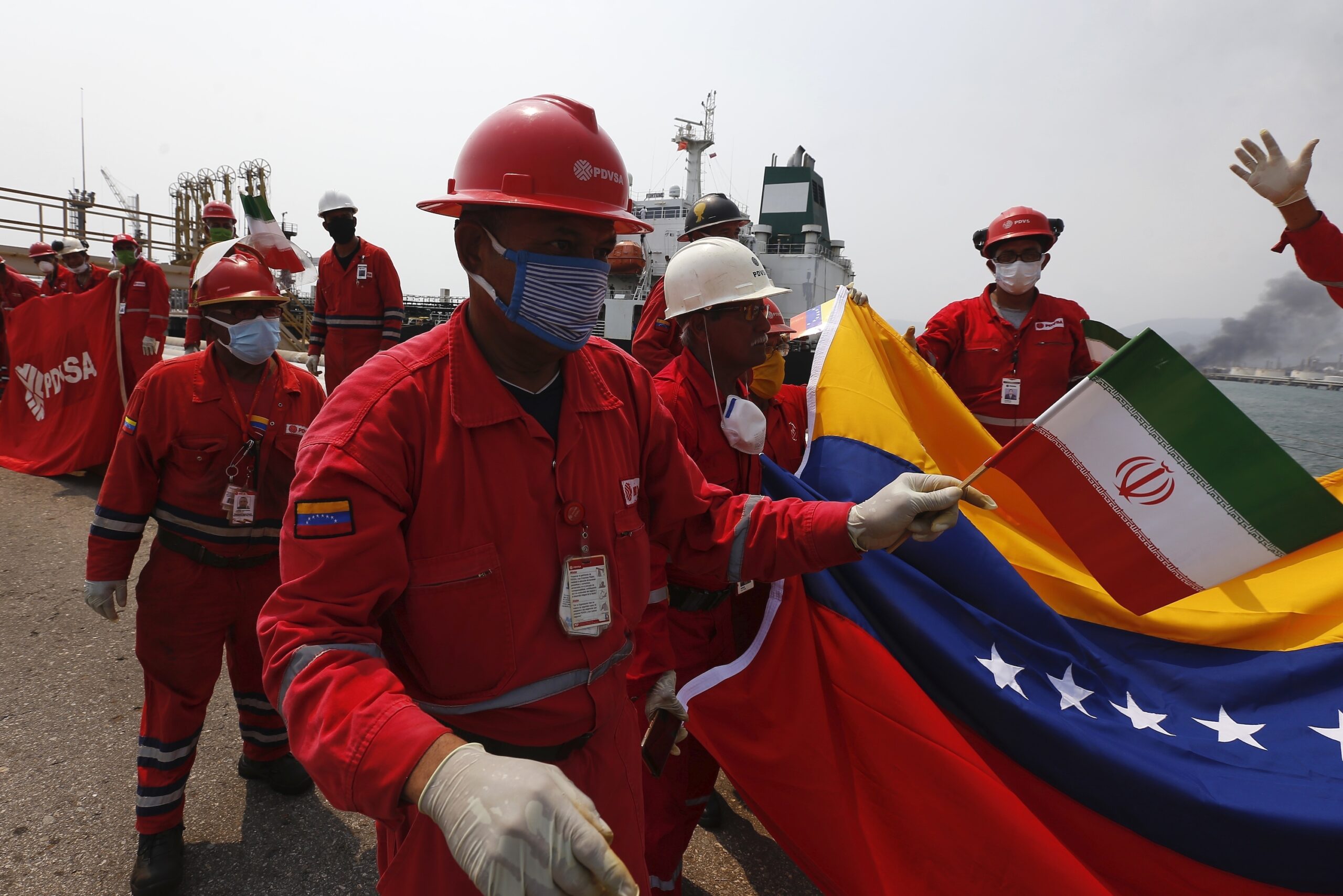 A Venezuelan oil worker holding a small Iranian flag attends a ceremony for the arrival of Iranian oil tanker Fortune at the El Palito refinery near Puerto Cabello, Venezuela, May 25. (AP Photo/Ernesto Vargas)