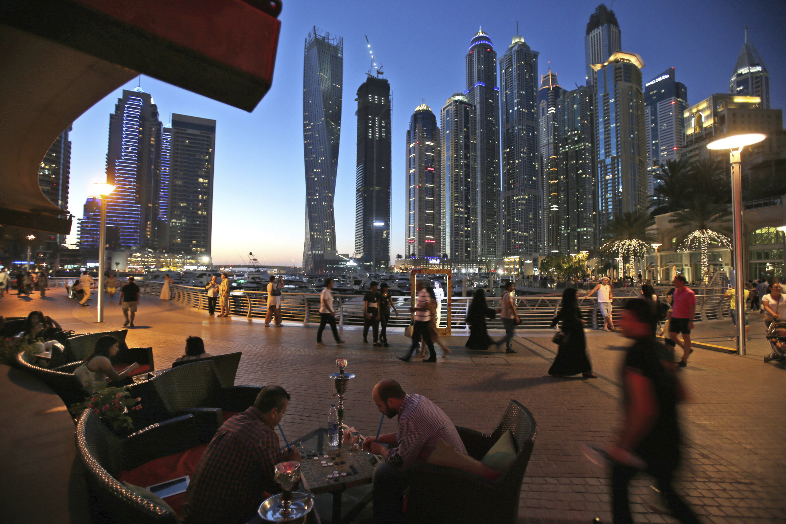 Two men play backgammon while smoking a shisha water pipe at a restaurant overlooking the canal and the Dubai Marina neighborhood in Dubai, United Arab Emirates, May 1, 2015. (AP Photo/Kamran Jebreili)