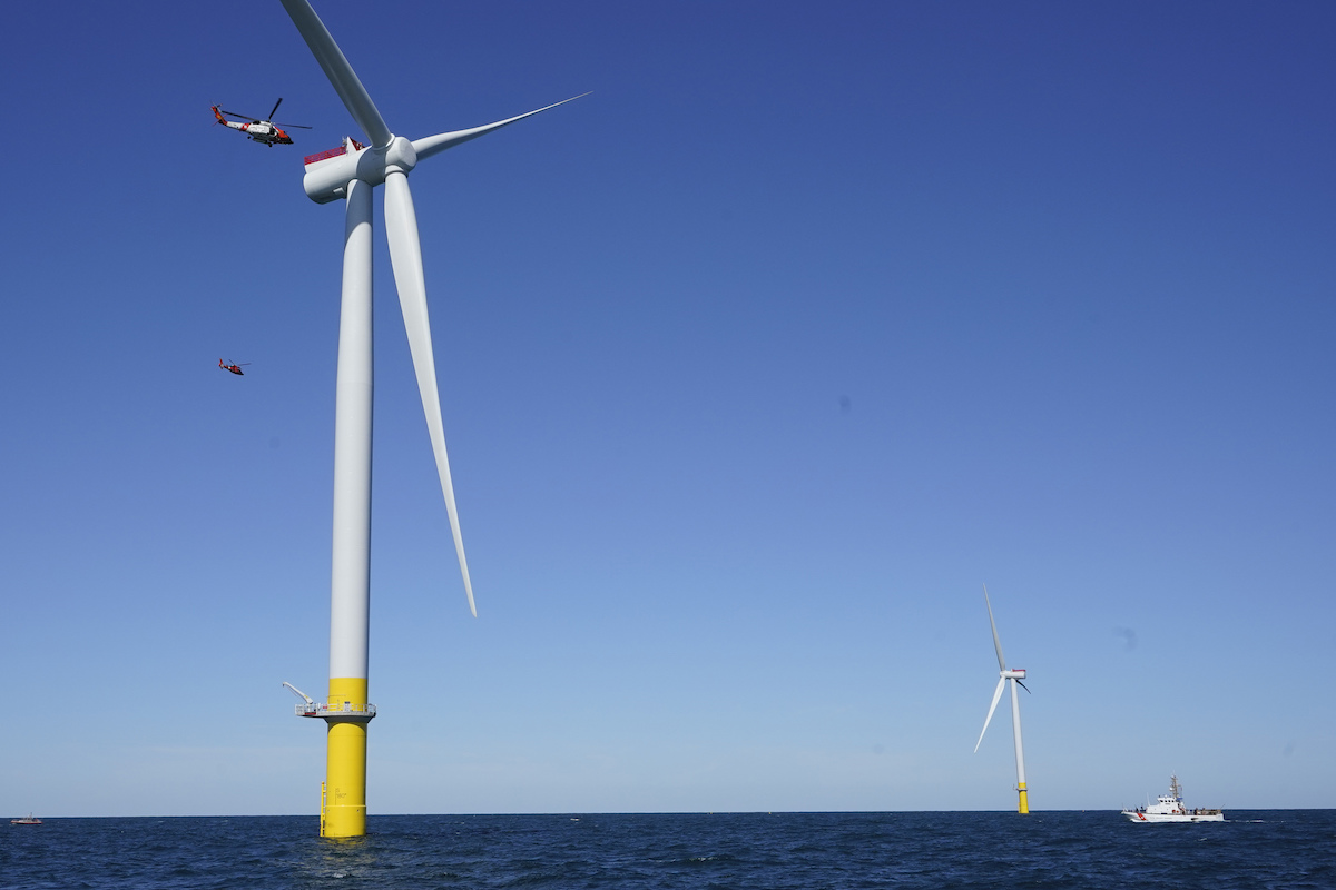 U.S. Coast Guard helicopters approach the top of a wind turbine nacelle during a training exercise 27 miles off the coast of Virginia, Oct. 14. (AP Photo/Steve Helber)