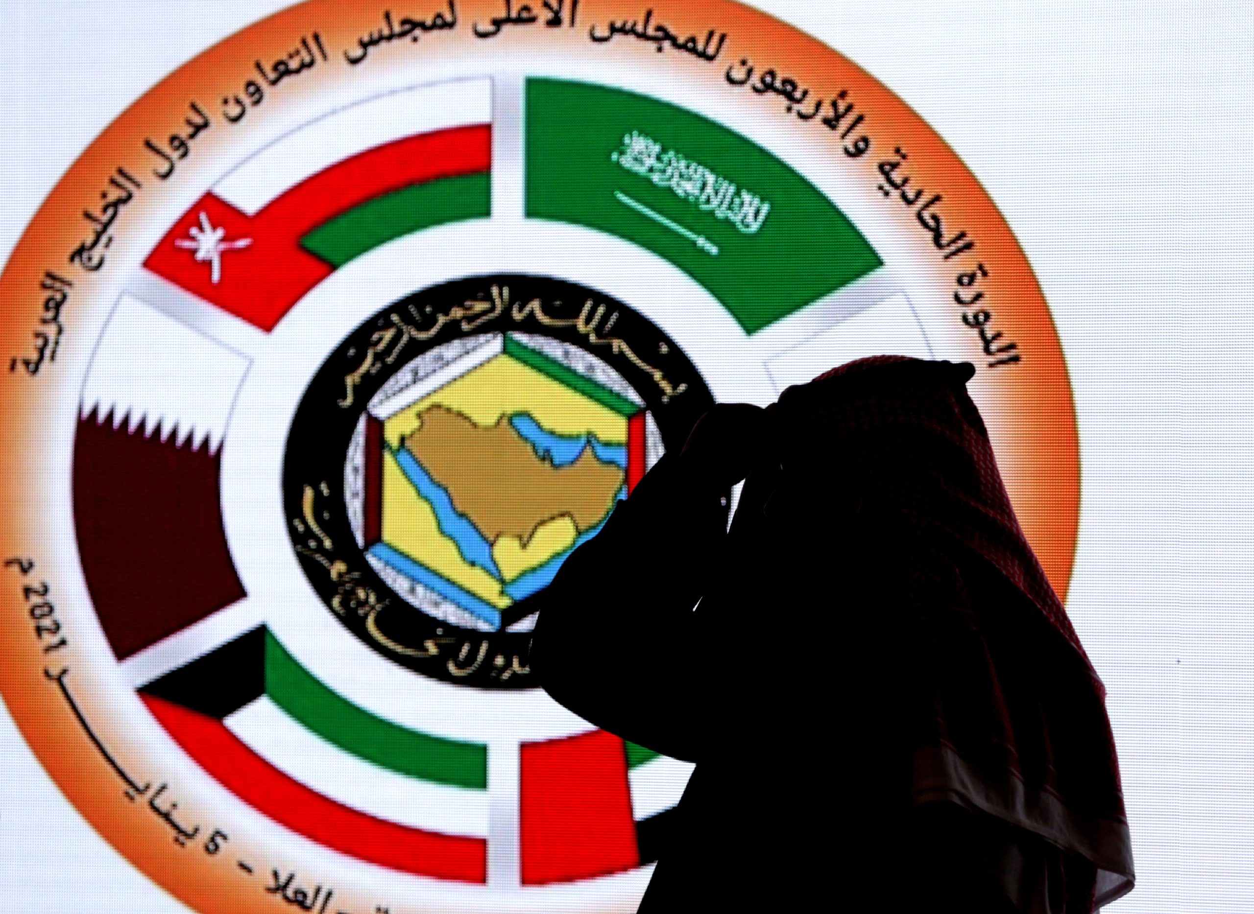 A Saudi television anchor stands in front of the logo for the 41st Gulf Cooperation Council meeting at the media center, in Al Ula, Saudi Arabia, Jan. 5. (AP Photo/Amr Nabil)
