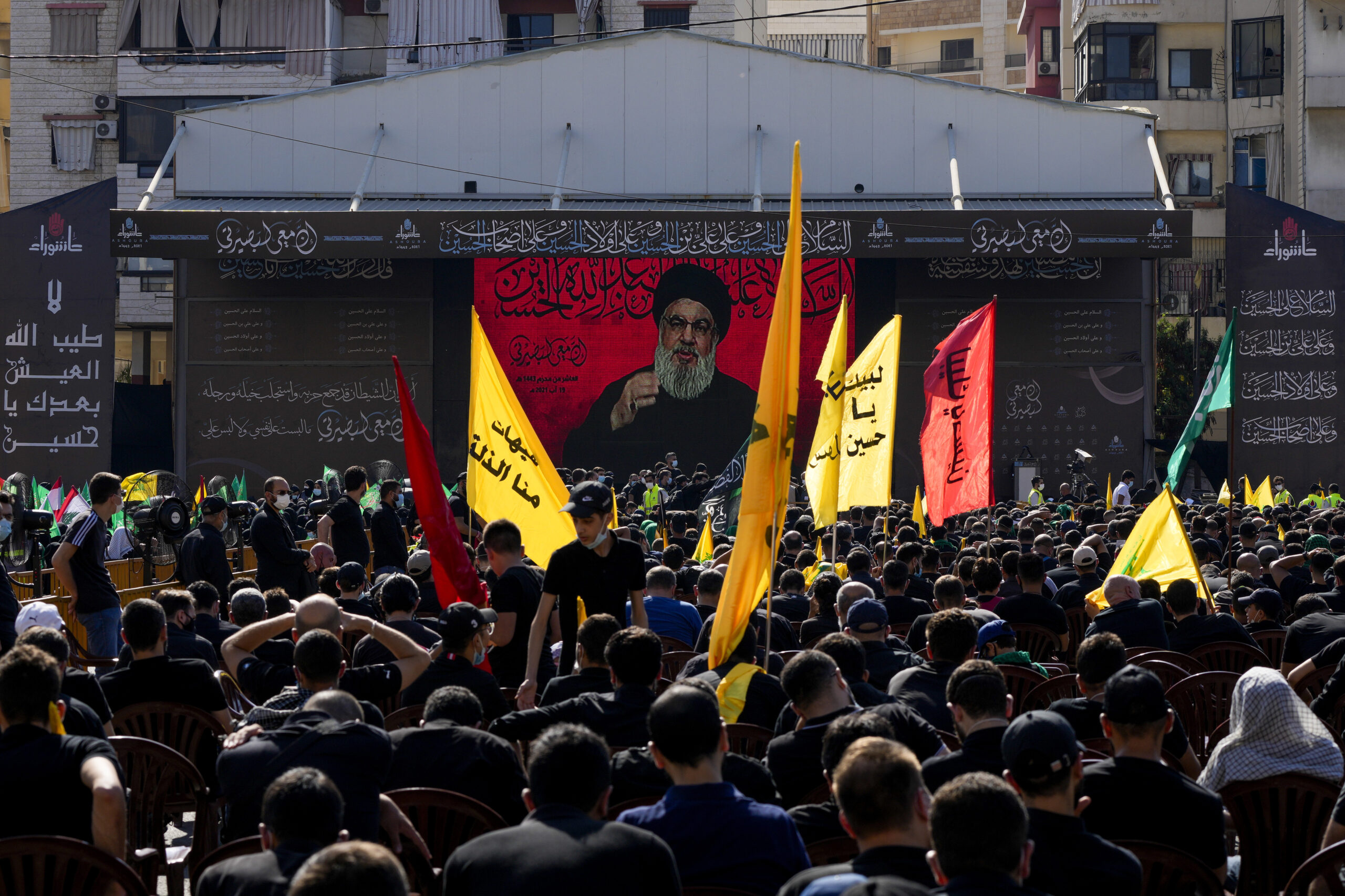 Hezbollah supporters listen to the group's leader, Hassan Nasrallah, as he speaks via video during a commemoration for Ashoura, Beirut, Lebanon, Aug. 19, 2021. (AP Photo/ Hassan Ammar)