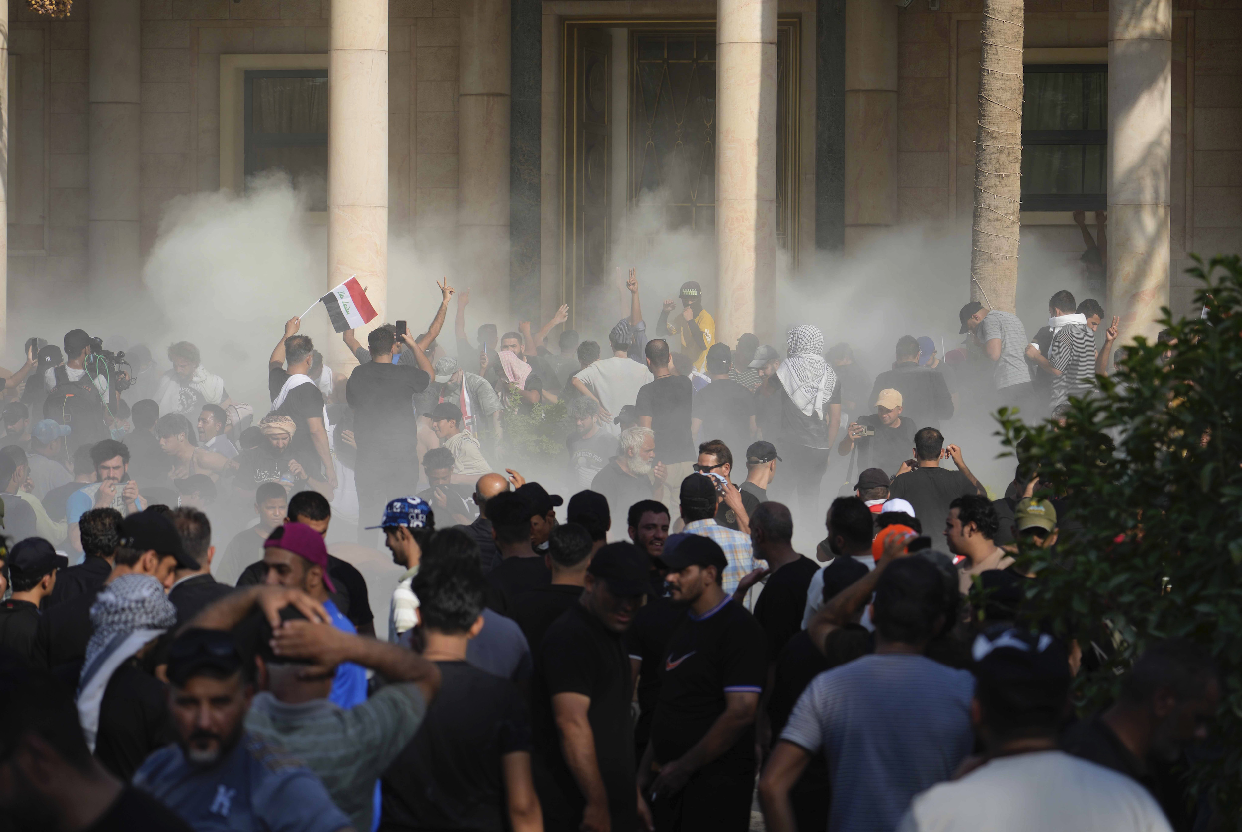 Iraqi security forces fire tear gas on the followers of Shia cleric Muqtada al-Sadr inside the government palace, Baghdad, Iraq, Aug. 29. (AP Photo/Hadi Mizban)
