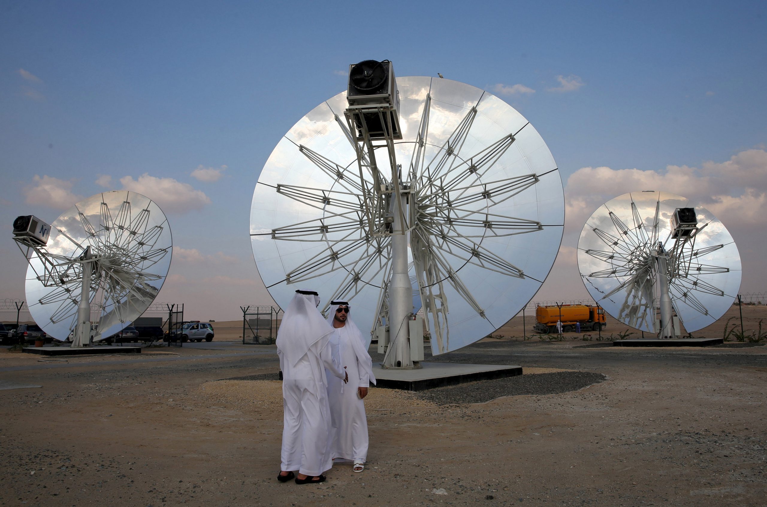 Men stand in front of solar panels at the Mohammed bin Rashid Al Maktoum Solar Park in Dubai, United Arab Emirates, November 28, 2015. (REUTERS/Stringer)