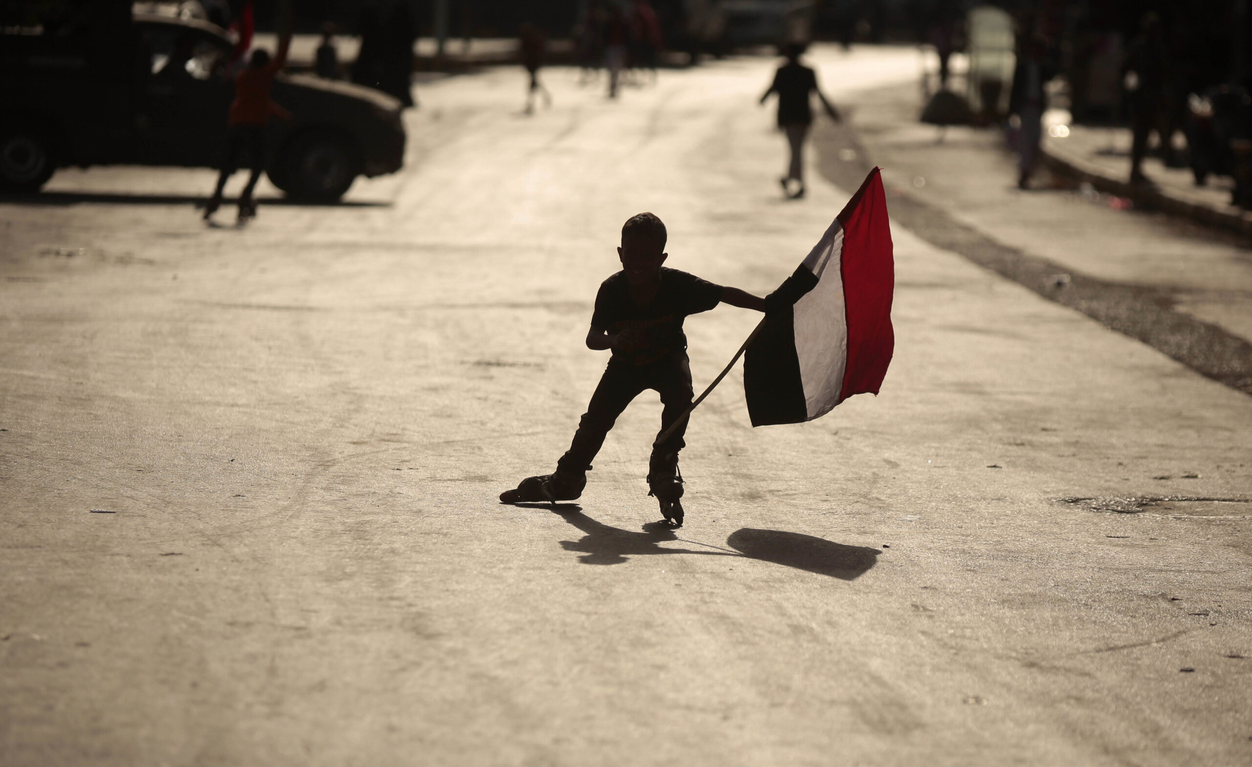 A boy holds a representation of the Yemeni flag as he roller-skates during a ceremony to mark the anniversary of North Yemen's Sept. 26, 1962 revolution in Sanaa, Yemen, Monday, Sept. 26, 2016. (AP Photo/Hani Mohammed)