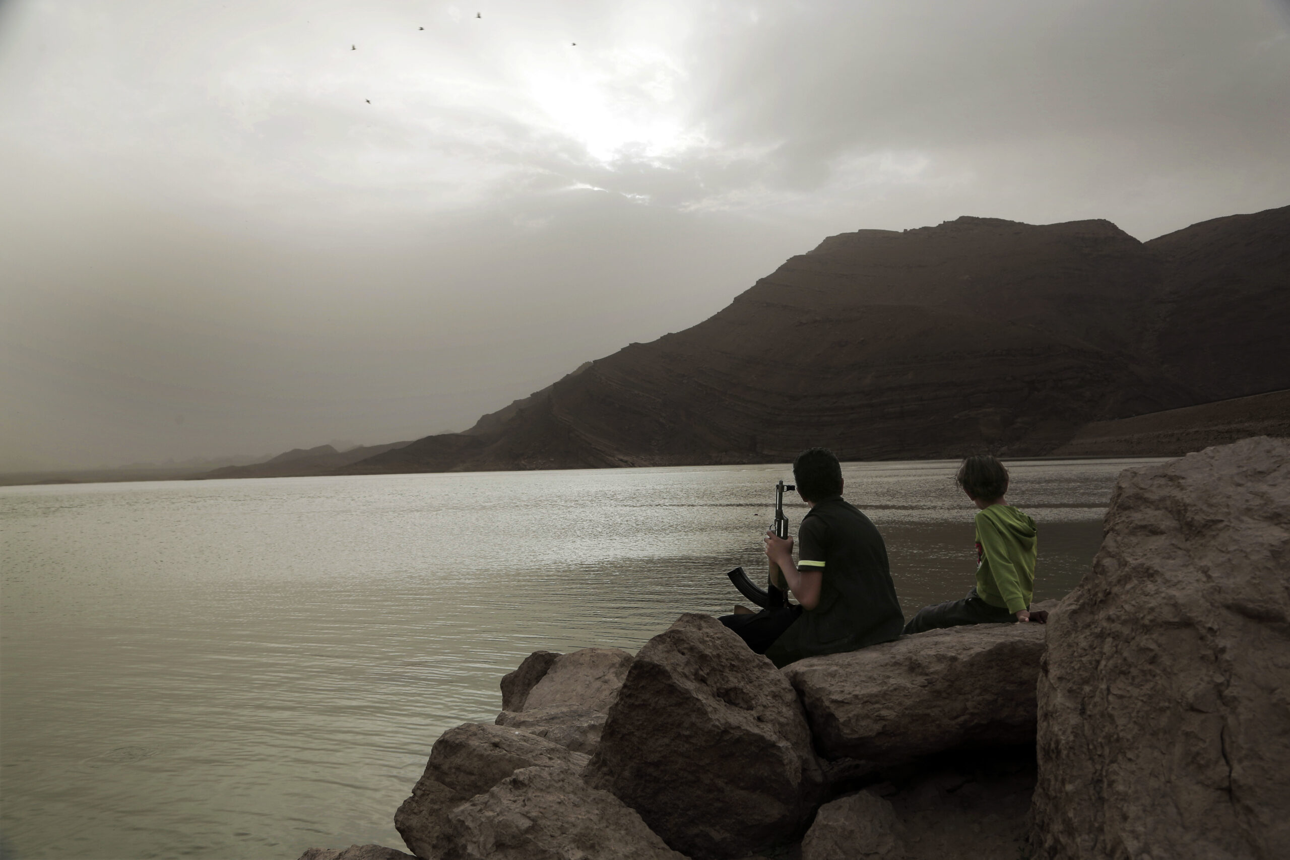 A boy holds an AK-47 while overlooking the high dam in Marib, Yemen, July 30, 2018. (AP Photo/Nariman El-Mofty)