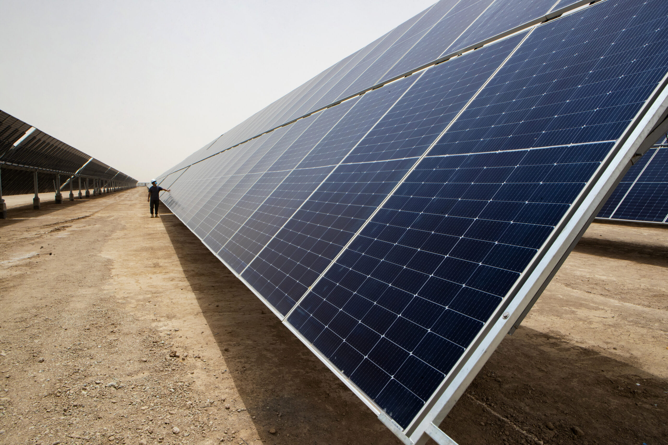 A worker inspects a panel at a solar power plant in the Faiha oil field east of Basra, Iraq, June 27, 2022. (AP Photo/Nabil al-Jurani)