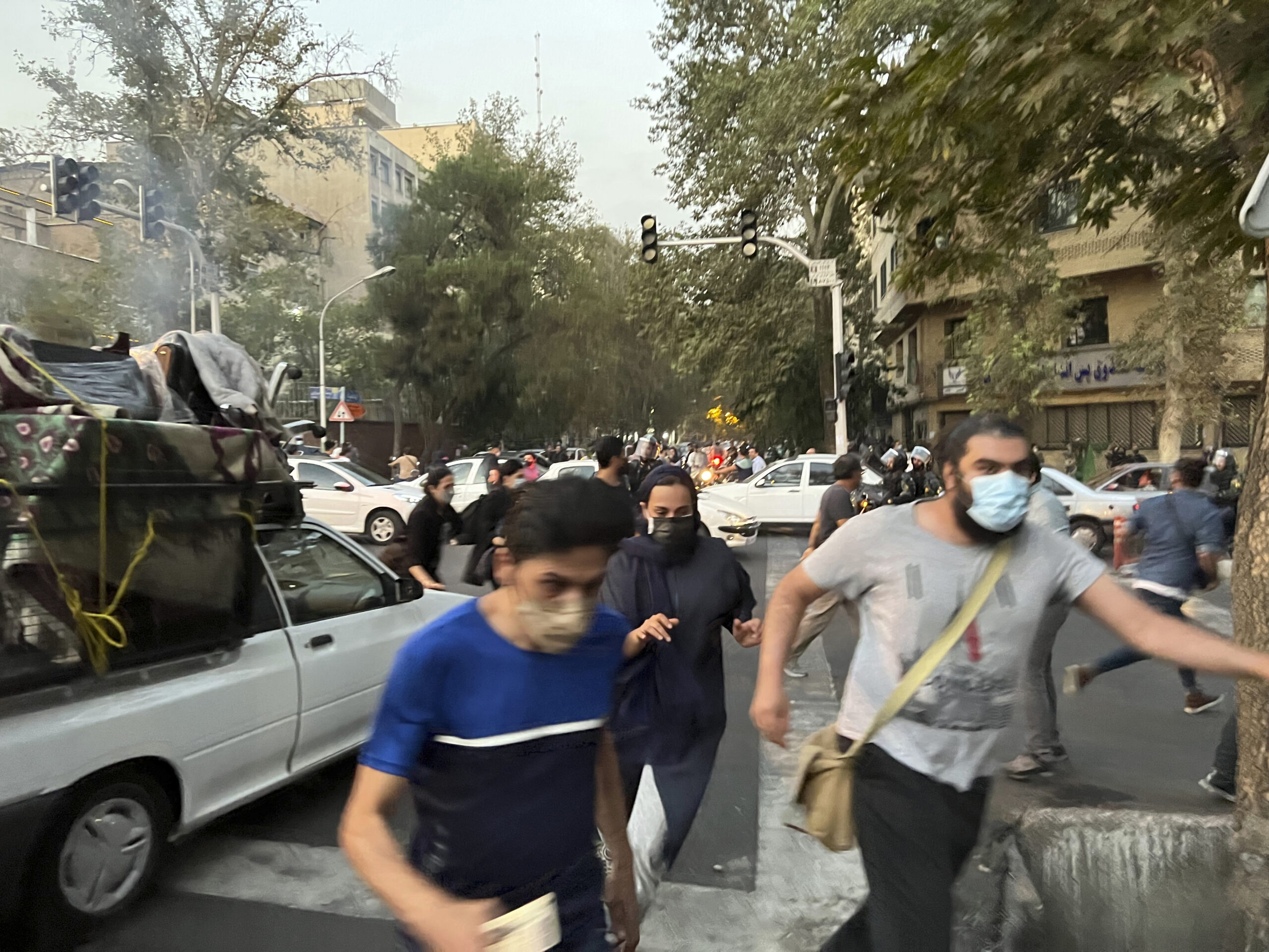 People run away from anti-riot police during a protest over the death of a young woman, Mahsa Amini, who had been detained for violating the country's conservative dress code, in downtown Tehran, Iran, September 10. (AP Photo)