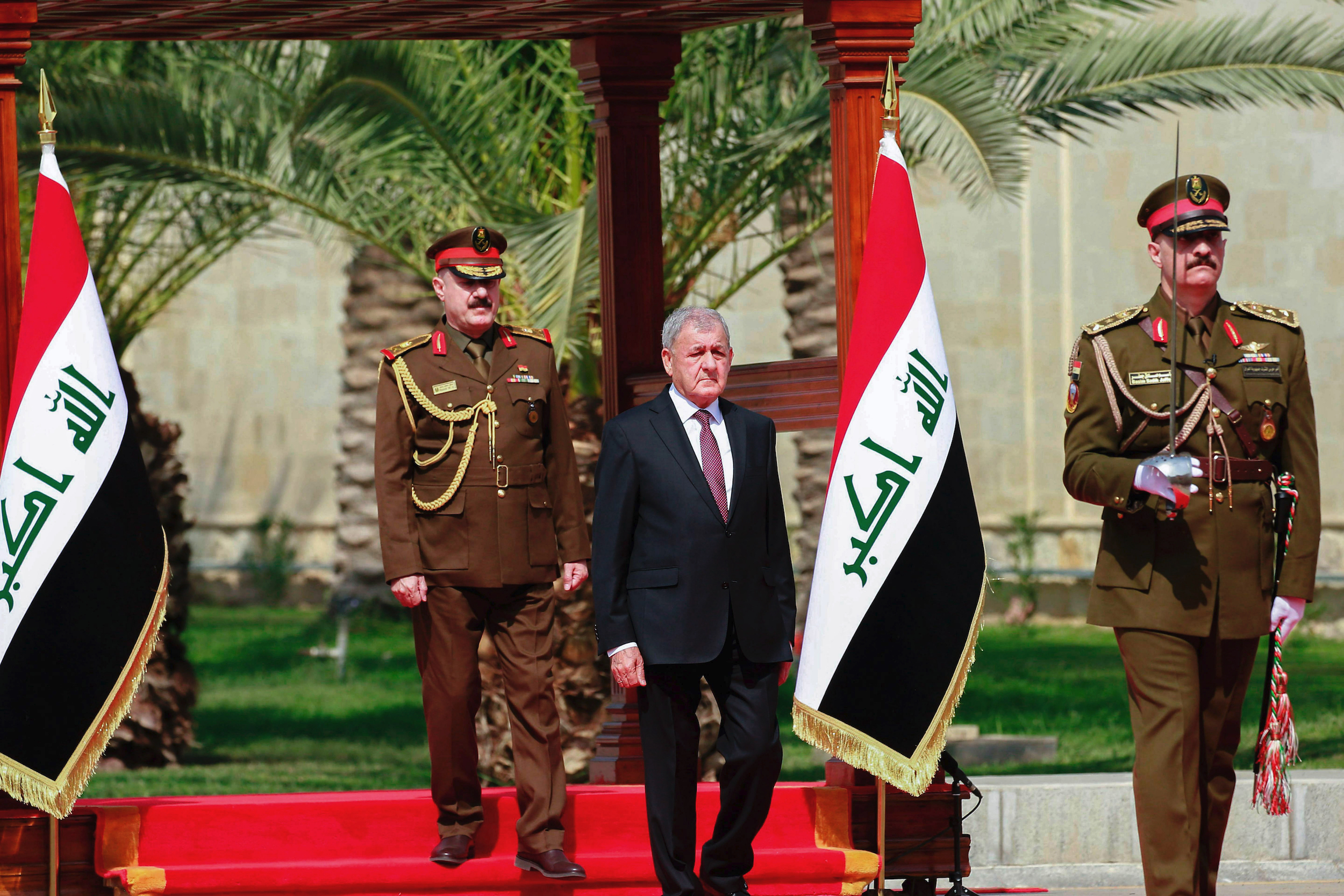 Newly elected Iraqi President Abdul Latif Rashid, center, inspects an honor guard, in Baghdad, Iraq, Oct. 17. (AP Photo/Hadi Mizban)