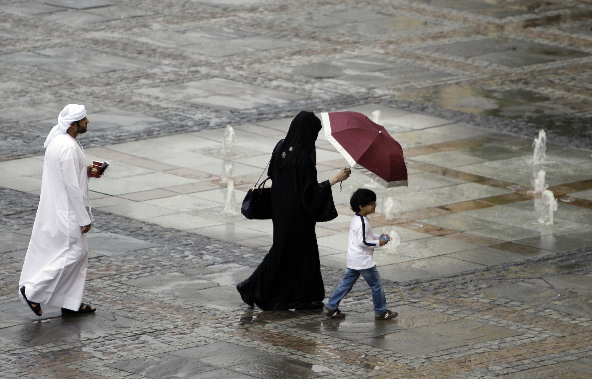 An Emirati family walking after a rain storm in Dubai, United Arab Emirates. (AP Photo/Kamran Jebreili)