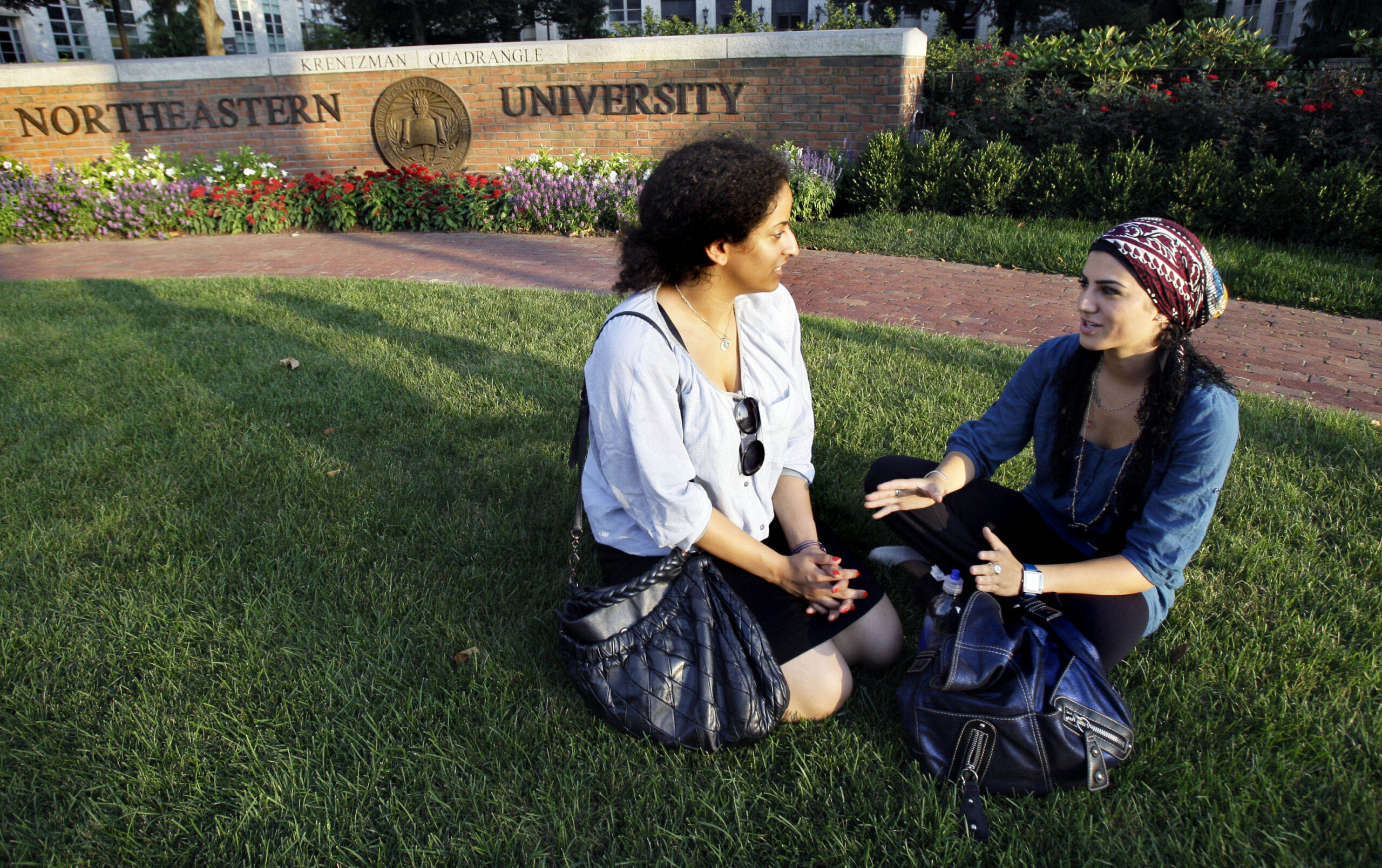 Saja Kamal, right, of Saudi Arabia chats with fellow student Alanoud Al-Buainain of Qatar as they sit on campus at Northeastern University in Boston, Massachusetts, Aug. 19, 2009. (AP Photo/Elise Amendola)