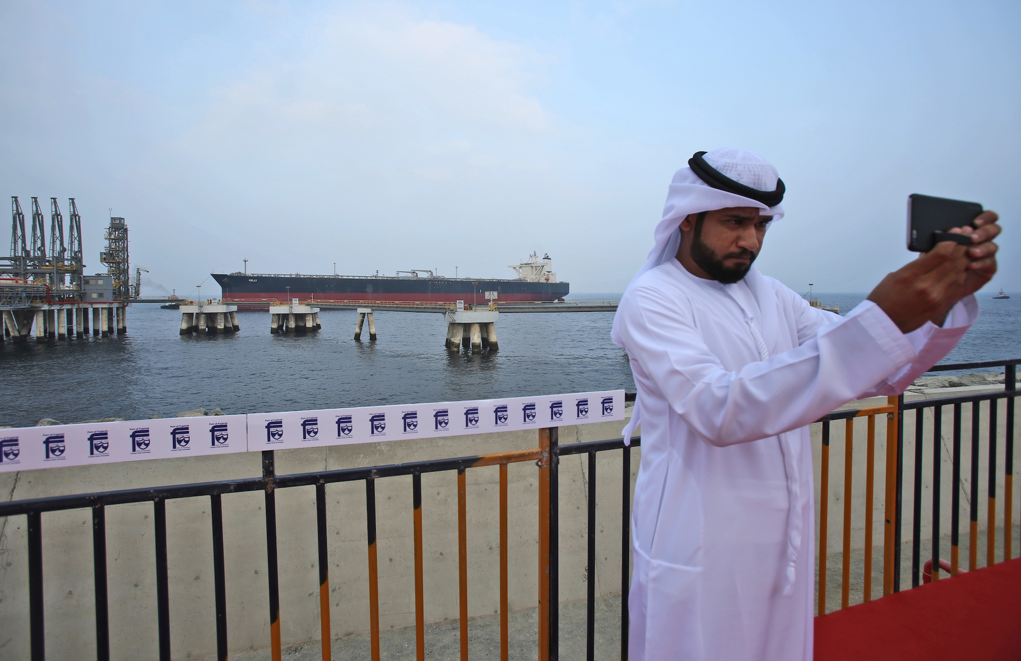 An Emirati man takes a selfie as an oil tanker approaches during the launch of the new oil facility in Fujairah, United Arab Emirates, Sept. 21, 2016. (AP Photo/Kamran Jebreili)