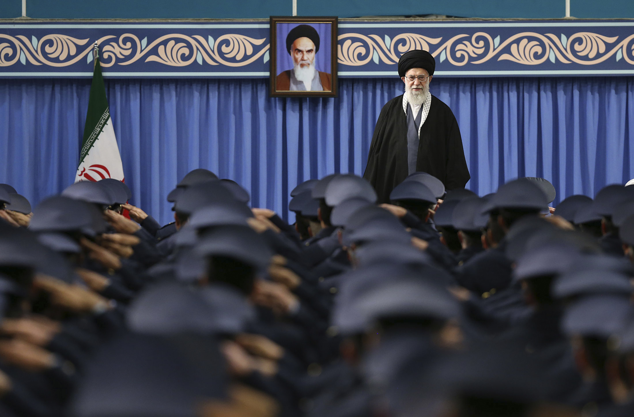 Iranian Supreme Leader Ayatollah Ali Khamenei stands as army air force and air defense staff salute at the start of their meeting in Tehran, Iran, Feb. 8, 2018. (Office of the Iranian Supreme Leader via AP)