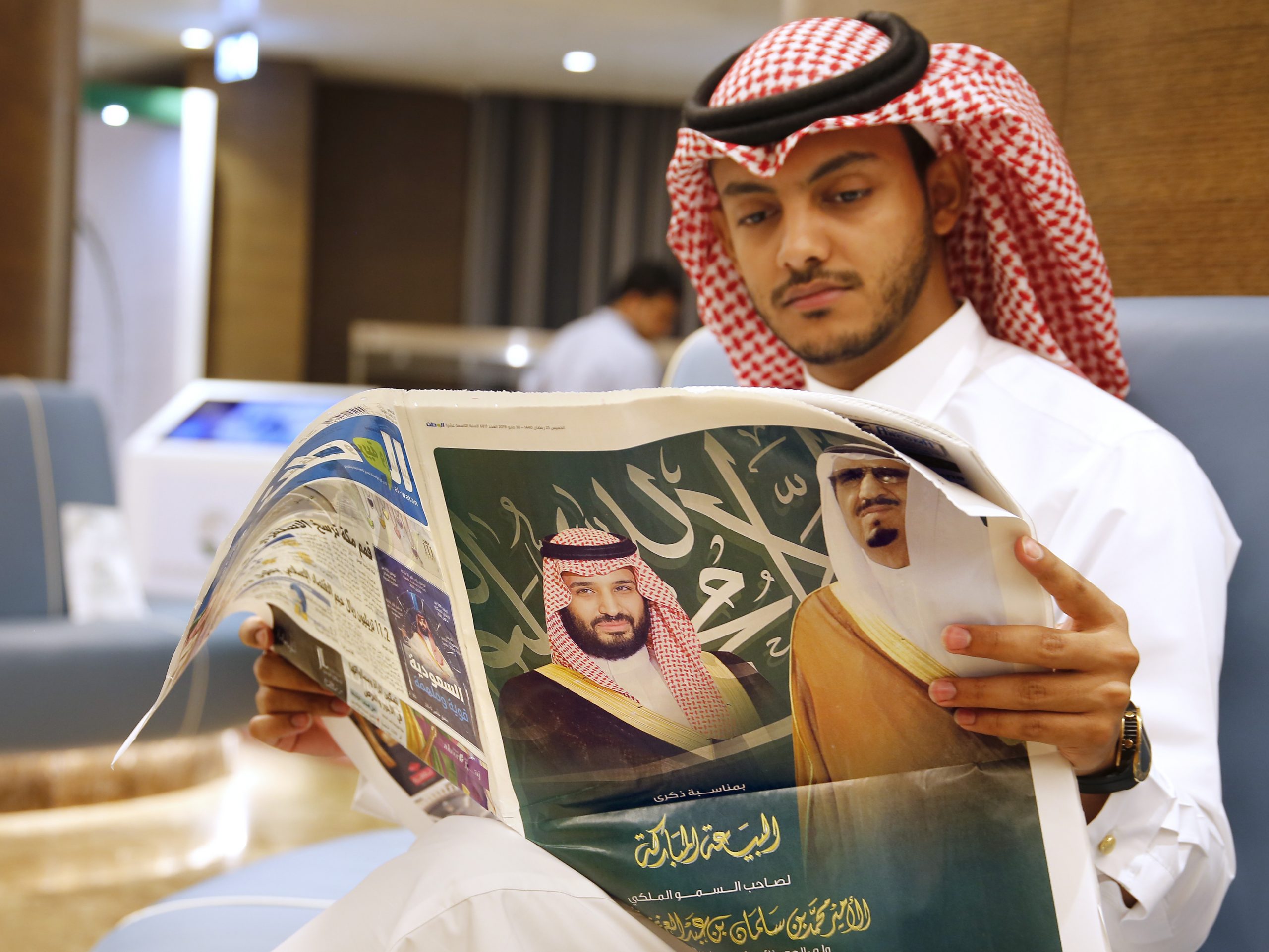 A man reads a newspaper with pictures of Saudi King Salman bin Abdulaziz, right, and Crown Prince Mohammed bin Salman, May 30, 2019. (AP Photo/Amr Nabil)