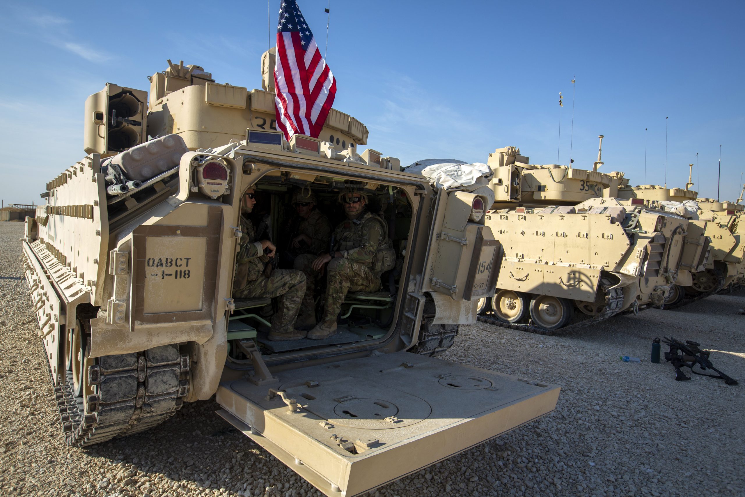 Crewmen sit inside Bradley fighting vehicles at a U.S. military base at an undisclosed location in northeastern Syria, Nov. 11, 2019. (AP Photo/Darko Bandic)