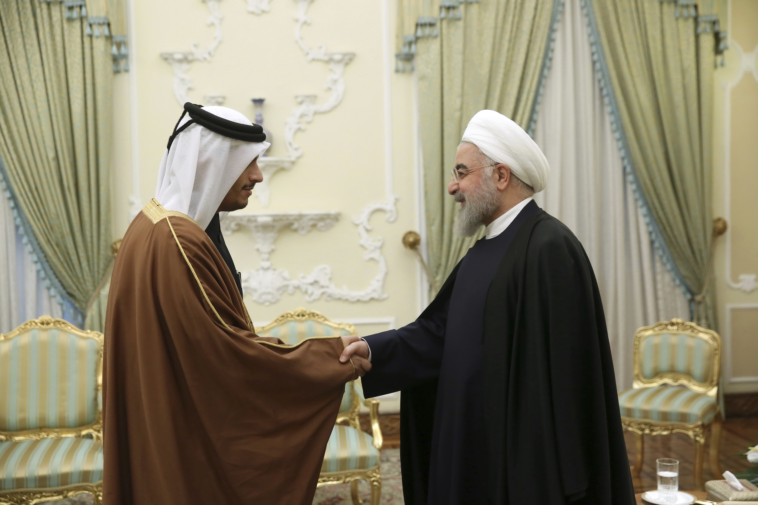 Iranian President Hassan Rouhani, right, welcomes Qatari Foreign Minister Mohammed bin Abdulrahman al-Thani for their meeting in Tehran, Iran, Jan. 4. (Office of the Iranian Presidency via AP)