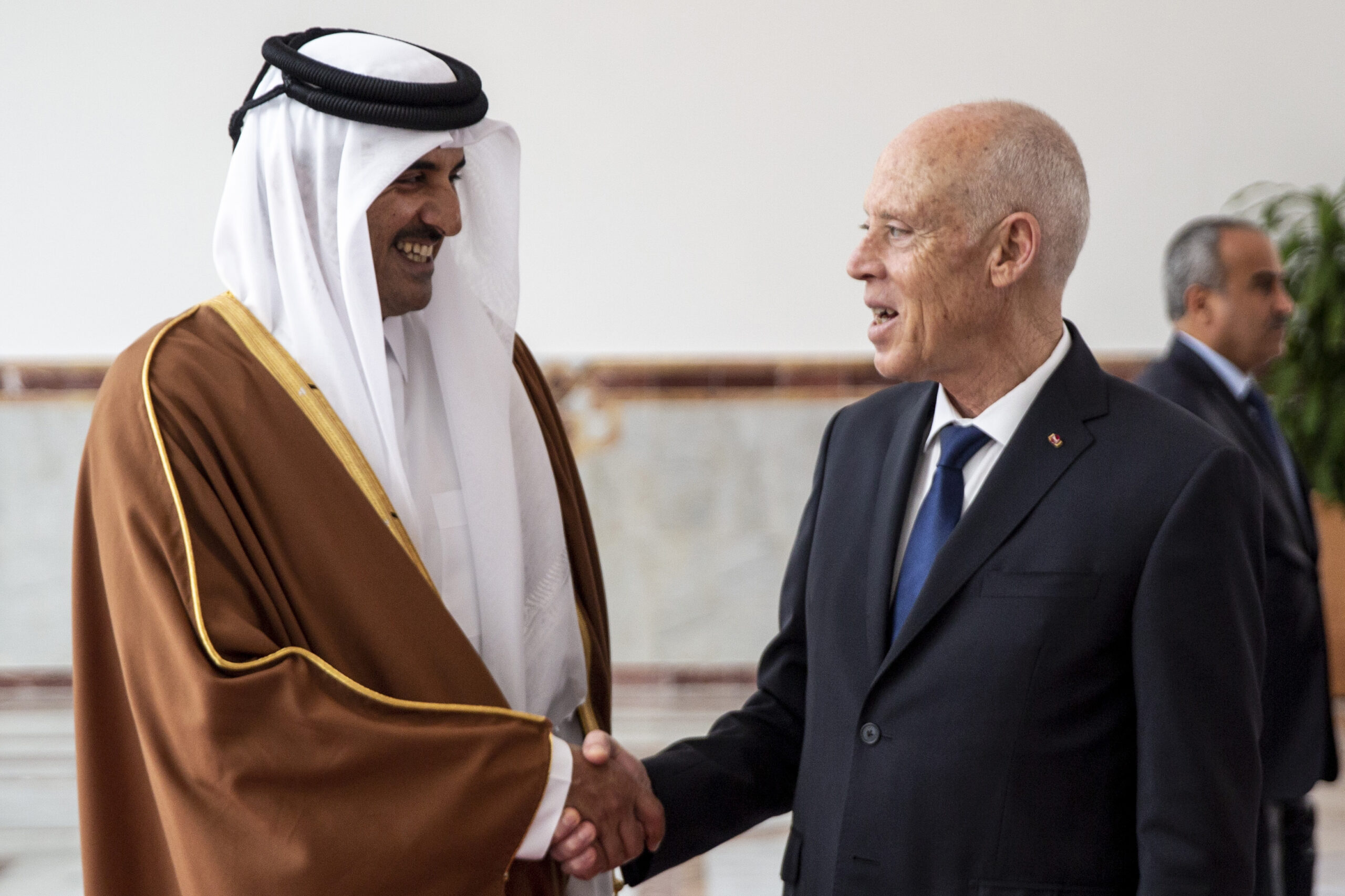 Tunisian President Kais Saied, right, shakes hands with Qatari Emir Tamim bin Hamad al-Thani upon his arrival in Tunis, Tunisia, Feb. 24. (AP Photo/Hassene Dridi)