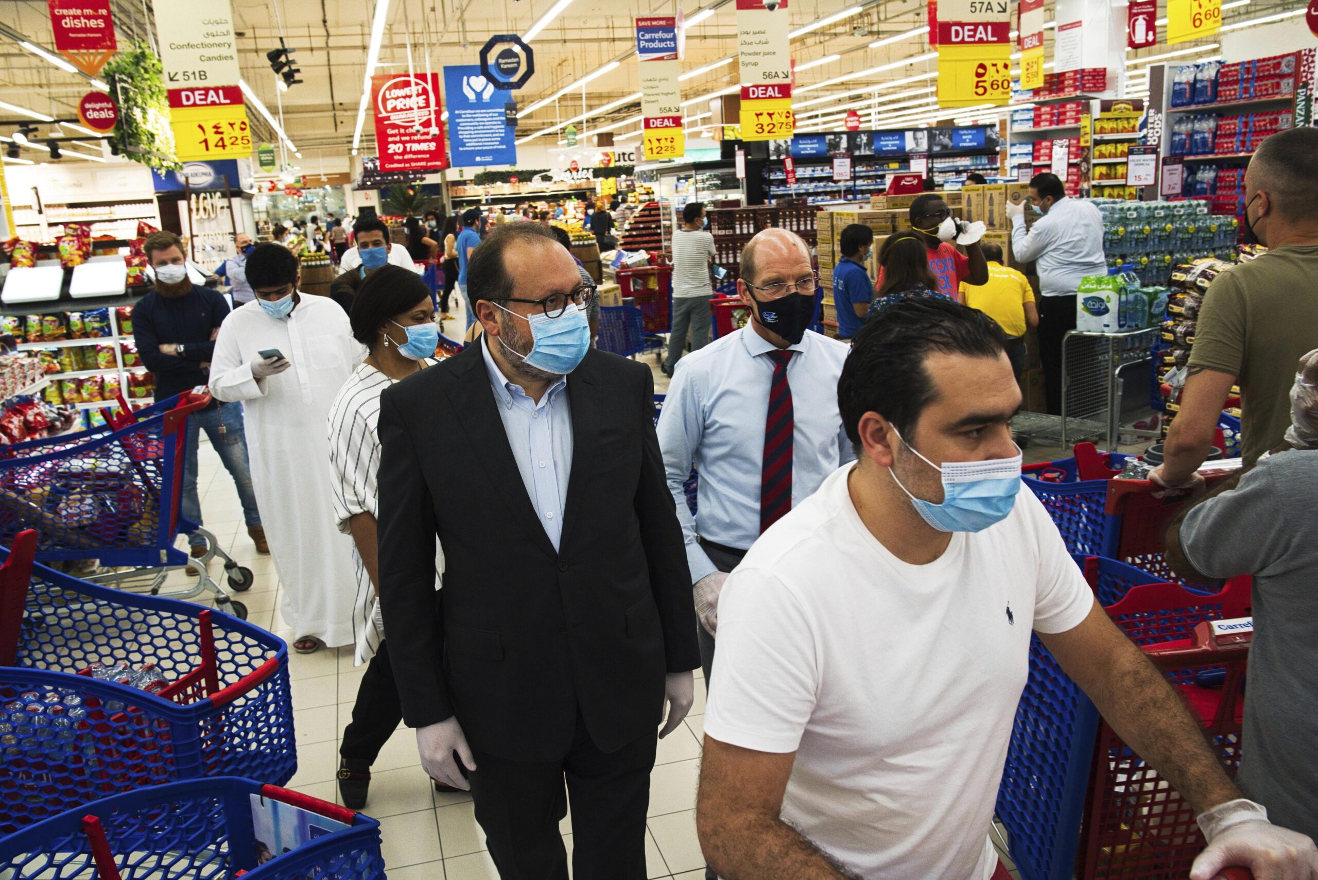 Majid Al Futtaim CEO Alain Bejjani, center left, and store manager Arnaud Bouf, center, walk through heavy shopping traffic in the world's busiest Carrefour supermarket, at the Mall of the Emirates in Dubai, United Arab Emirates, April 19, 2020. (AP Photo/Jon Gambrell)