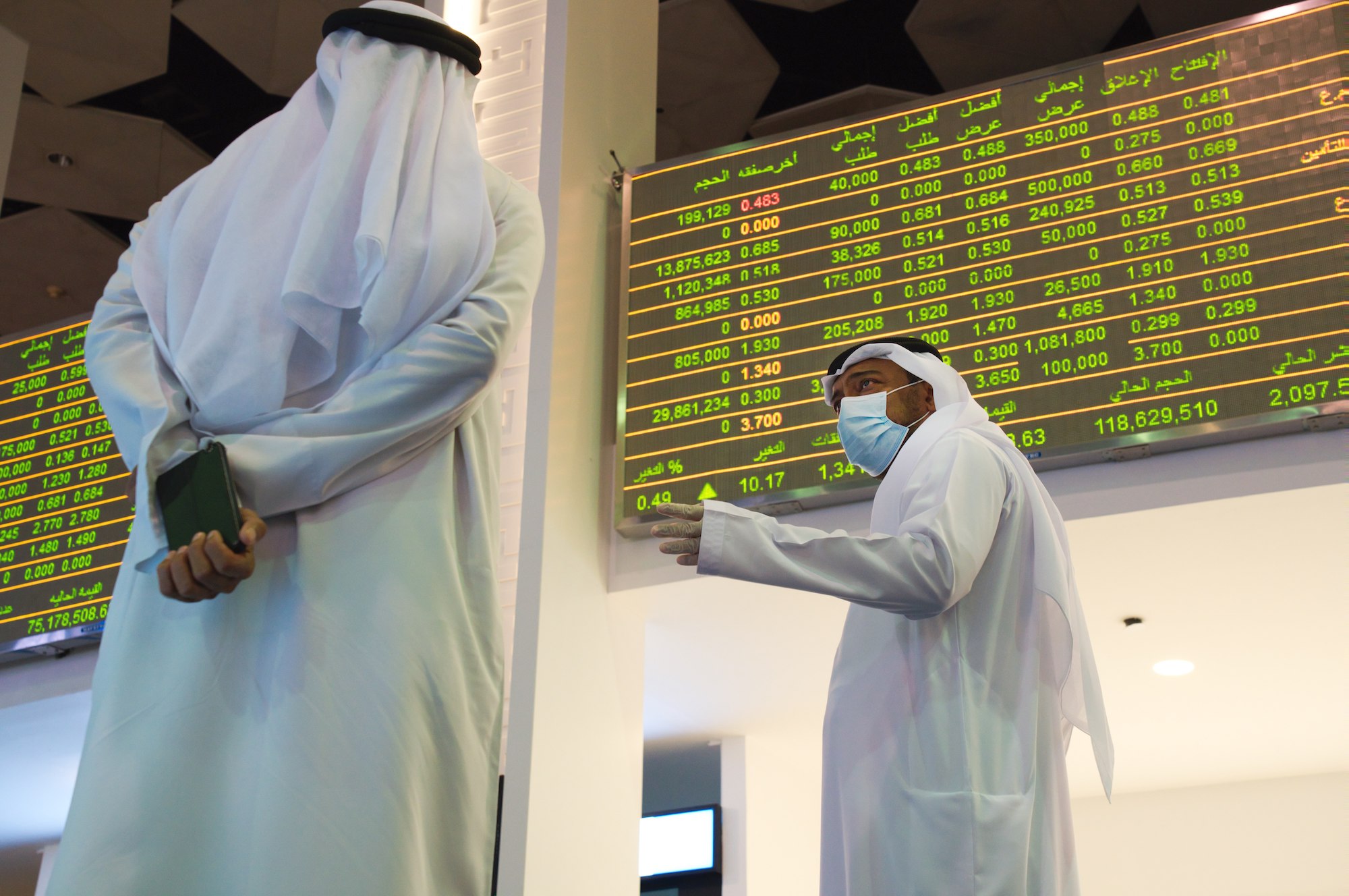 Jamal al-Khadhar, an executive vice president of the Dubai Financial Market, talks to a man on the floor of the exchange in Dubai, United Arab Emirates, July 7. (AP Photo/Jon Gambrell)