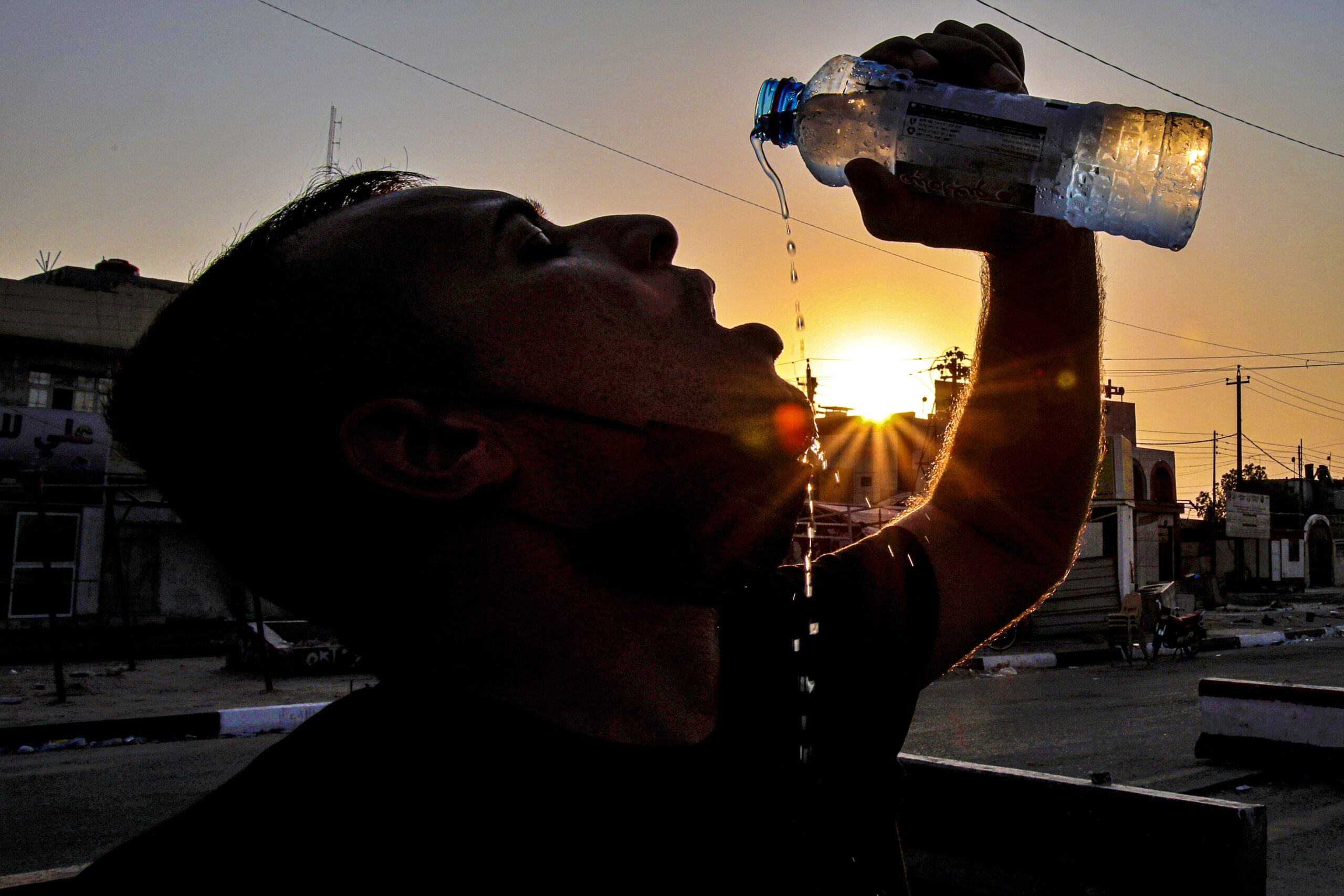 Laith Jabbar, a gas station worker drinks water in Basra, Iraq, July. 27, 2020. (AP Photo/Nabil al-Jurani)