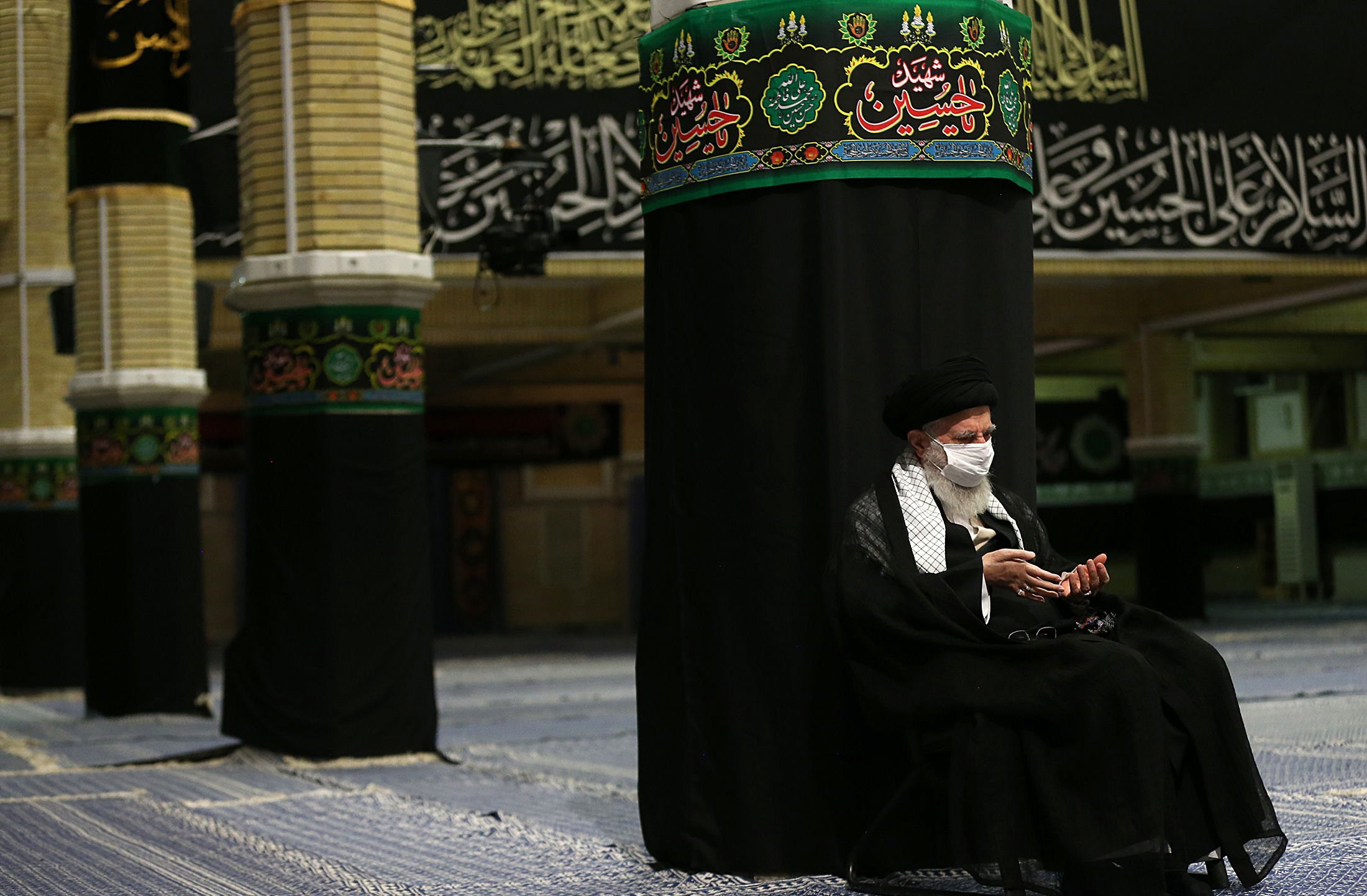 Iran'sSupreme Leader Ayatollah Ali Khamenei wears a protective face mask to help prevent spread of the coronavirus as he listens to a reciting of the Quran and a speaker at the empty mosque in his residence compound in Tehran, Iran, Aug. 26. (Office of the Iranian Supreme Leader via AP)