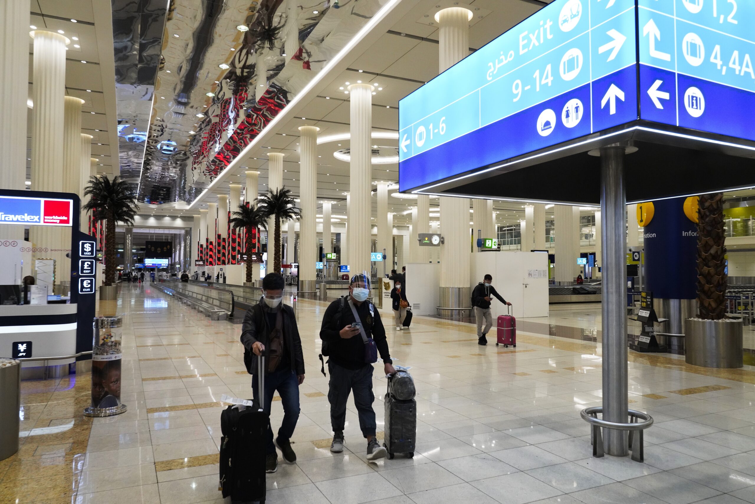 Passengers arrive at the baggage claim area of Dubai International Airport's Terminal 3, Dubai, United Arab Emirates, Nov. 26, 2020. (AP Photo/Jon Gambrell)