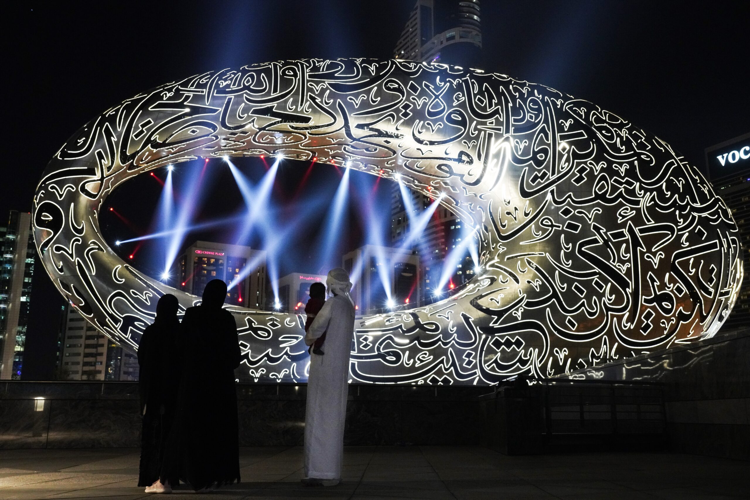 An Emirati family looks at the under-construction Museum of the Future in Dubai, United Arab Emirates, Dec. 2, 2020. (AP Photo/Jon Gambrell)