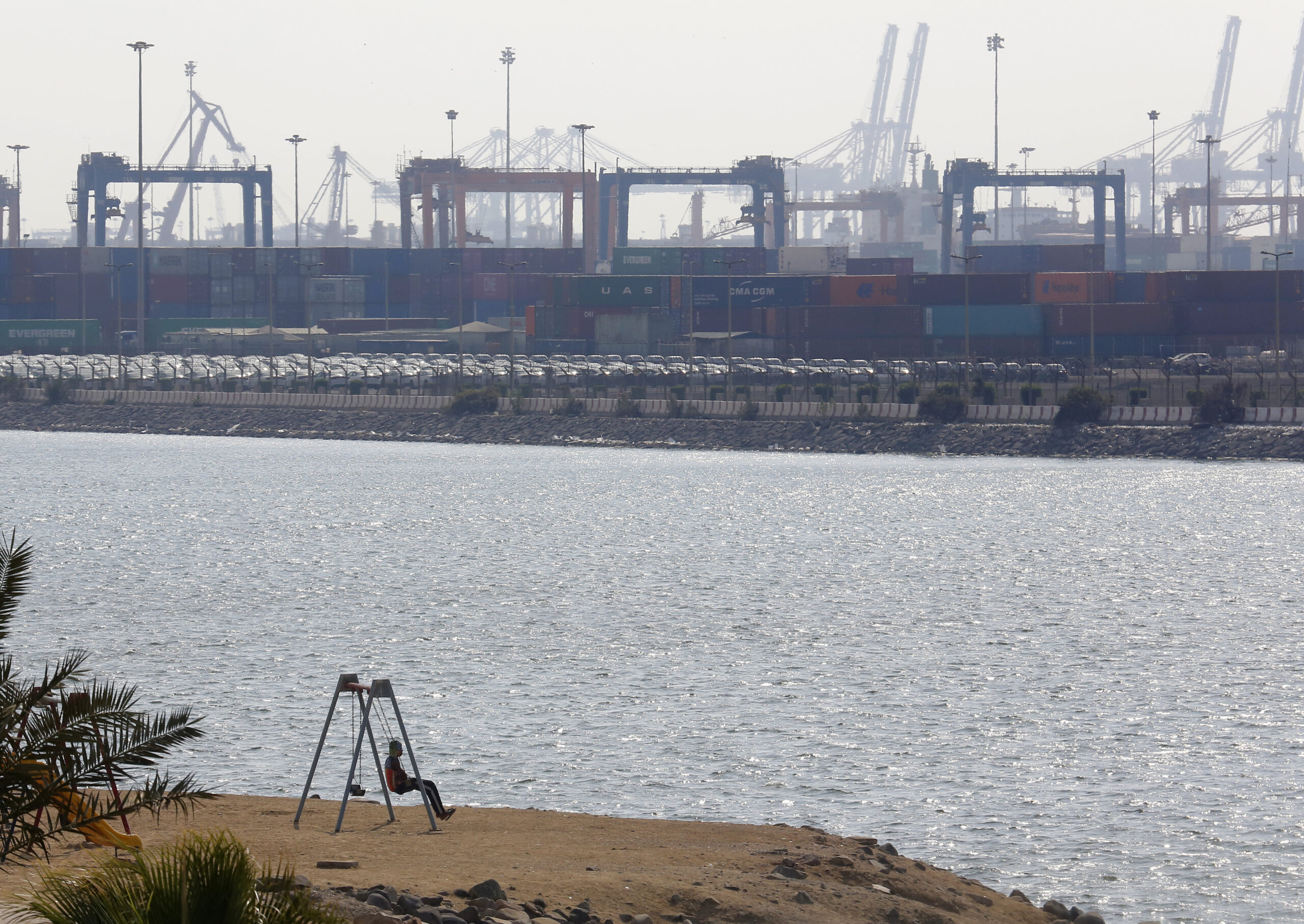 A boy swings in front of a port in Jeddah, Saudi Arabia, Dec.14, 2020. (AP Photo/Amr Nabil)