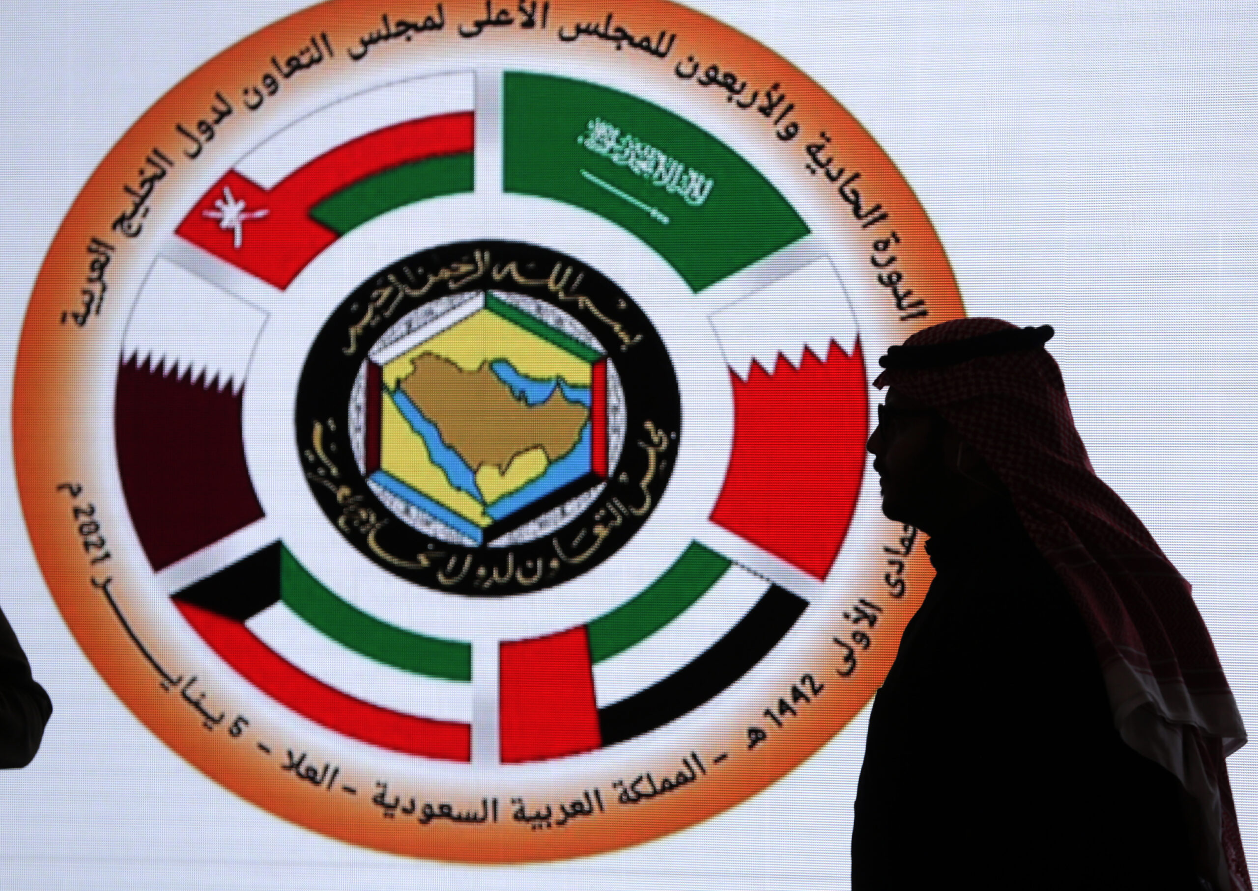 A Saudi television anchor stands in front of the logo of the Gulf Cooperation Council at the media center in at Al Ula, Saudi Arabia, Jan. 5. (AP Photo/Amr Nabil)
