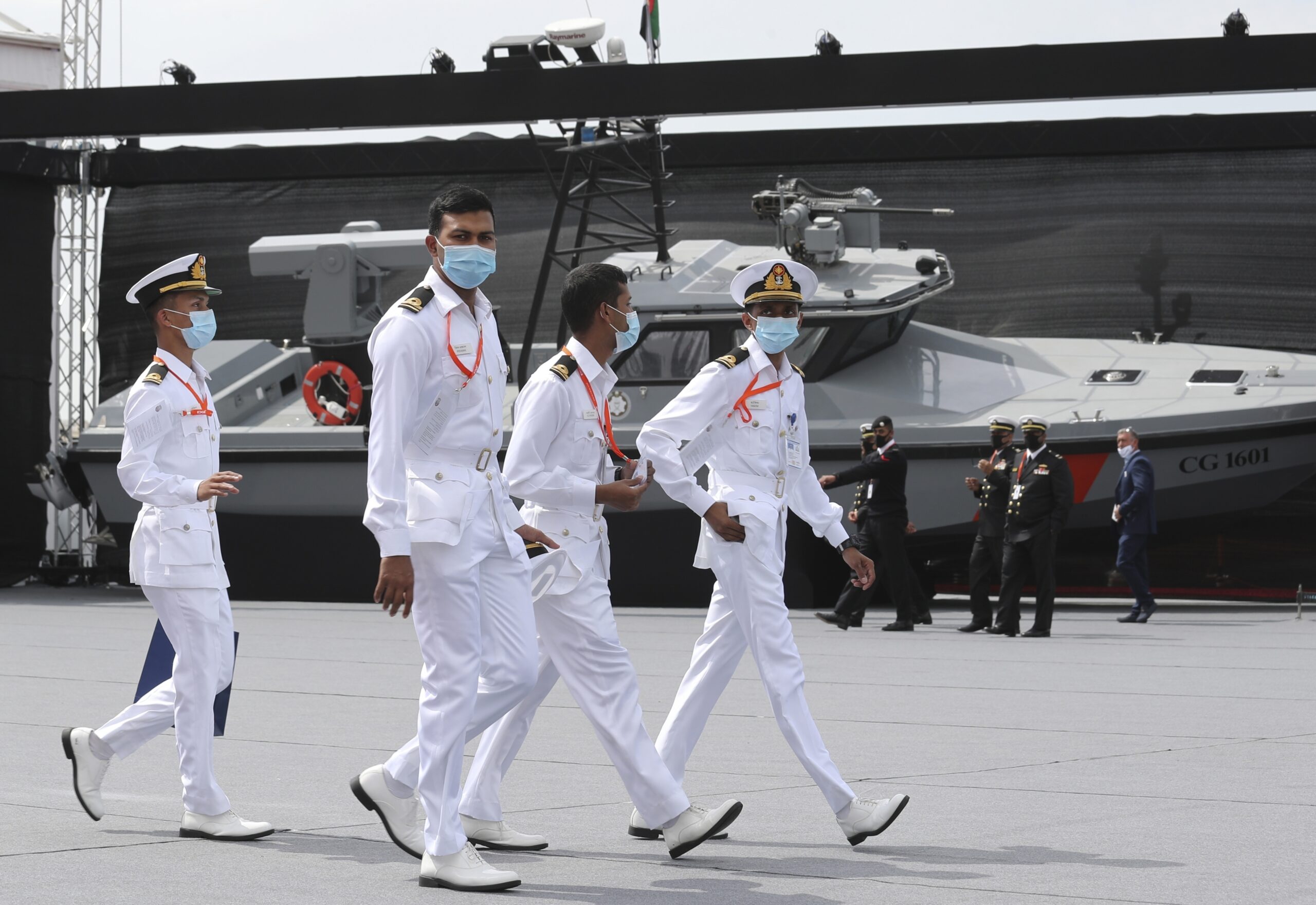 Emirati naval officers walk past a combat boat on the opening day of the Naval Defence & Maritime Security Exhibition in Abu Dhabi, United Arab Emirates, Feb. 21. (AP Photo/Kamran Jebreili)