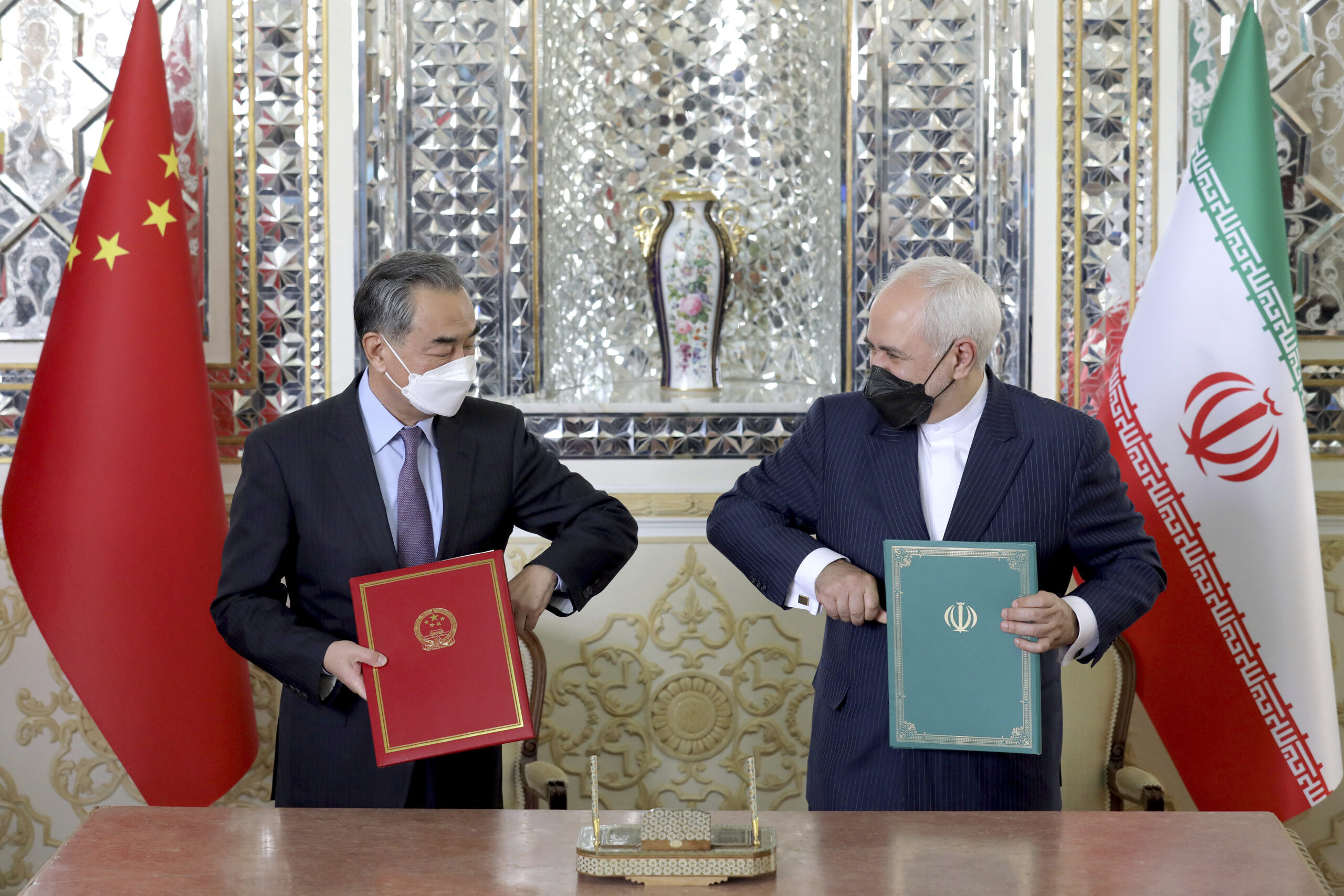 China's foreign minister, Wang Yi, left, and Mohammad Javad Zarif, then Iran's foreign minister, pose for photos after the ceremony of signing a 25-year strategic cooperation agreement in Tehran, Iran, March 27, 2021.