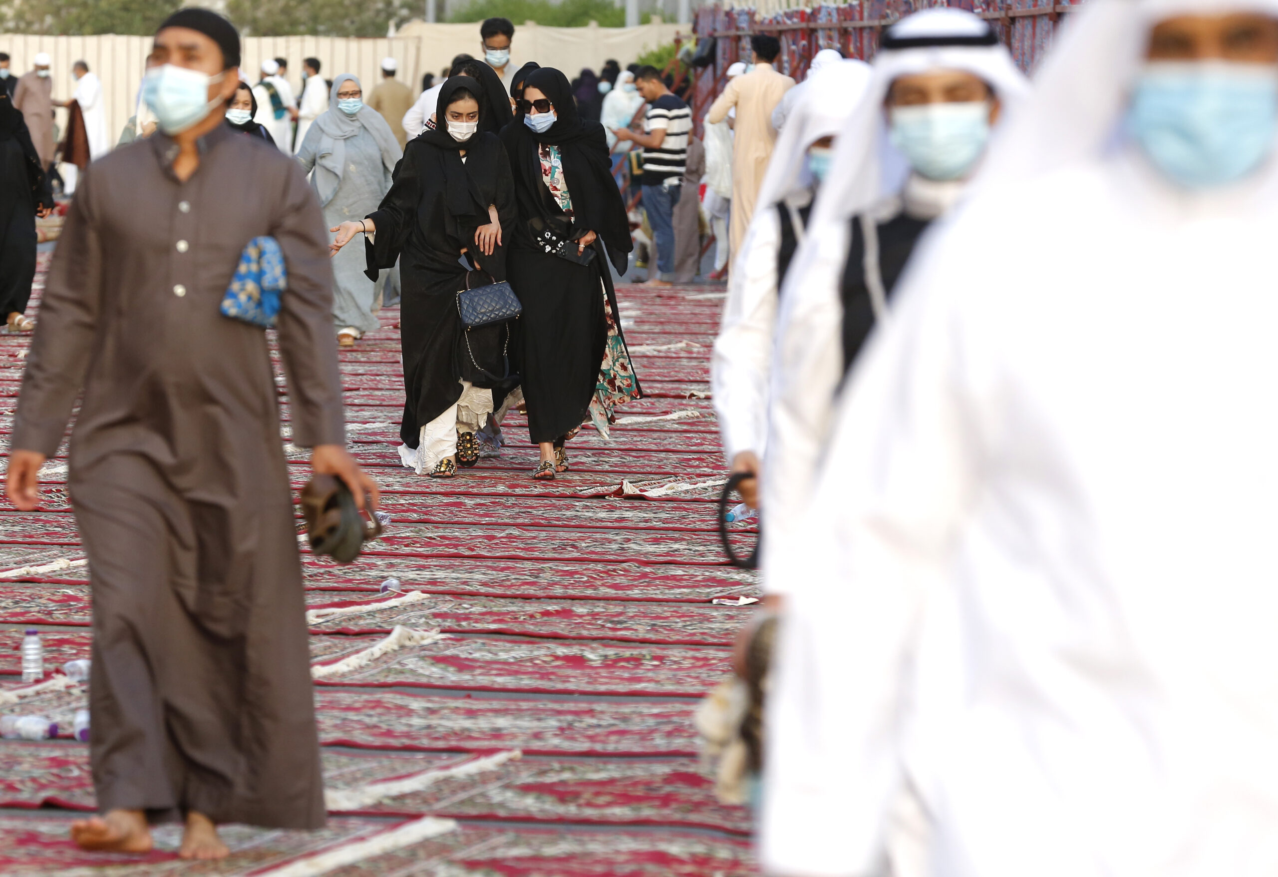 Women wearing masks to curb the spread of coronavirus, center, walk performing Eid al-Fitr prayers marking the end of the holy month of Ramadan, Jeddah, Saudi Arabia, May 13, 2021. (AP Photo/Amr Nabil)