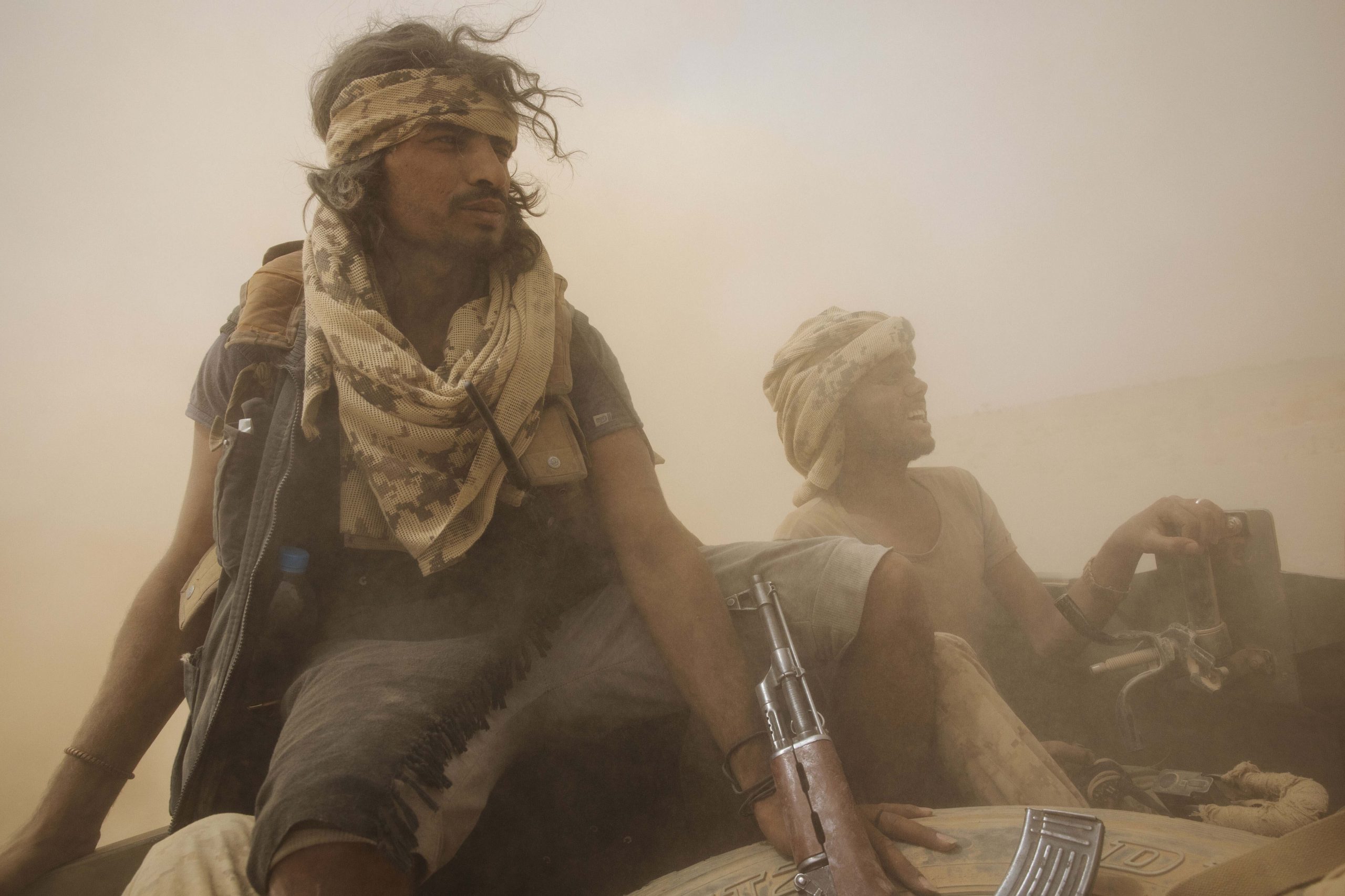 Yemeni fighters backed by the Saudi-led coalition ride on the back of an armored vehicle as they leave the front lines near Marib, Yemen, June 19. (AP Photo/Nariman El-Mofty)