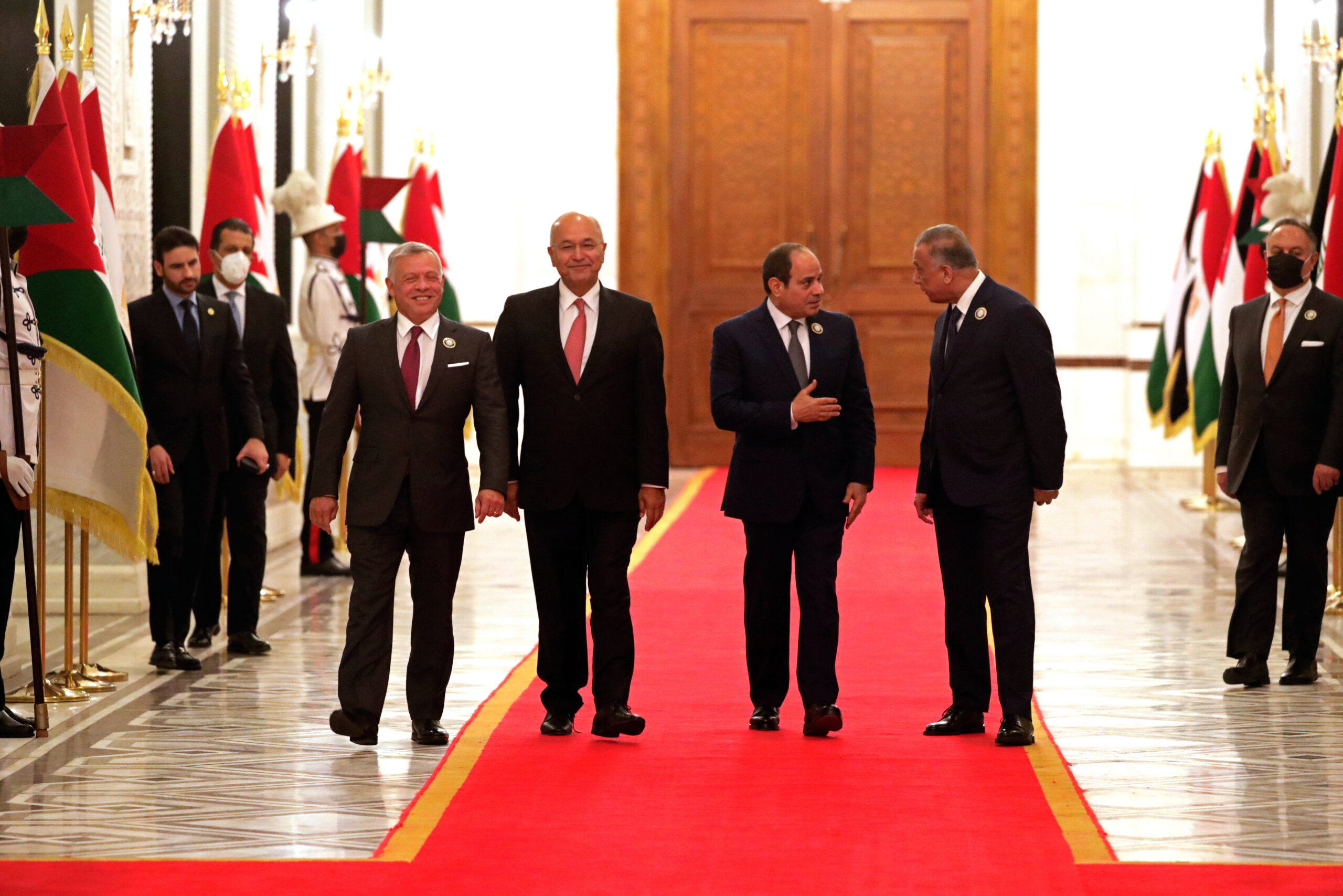 From left to right, Jordanian King Abdullah II, Iraqi President Barham Salih, Egyptian President Abdel Fattah al-Sisi, and Iraqi Prime Minister Mustafa al-Kadhimi, prepare to meet in the presidential palace in Baghdad, Iraq, Sunday, June 27, 2021. (AP Photo/Khalid Mohammed)