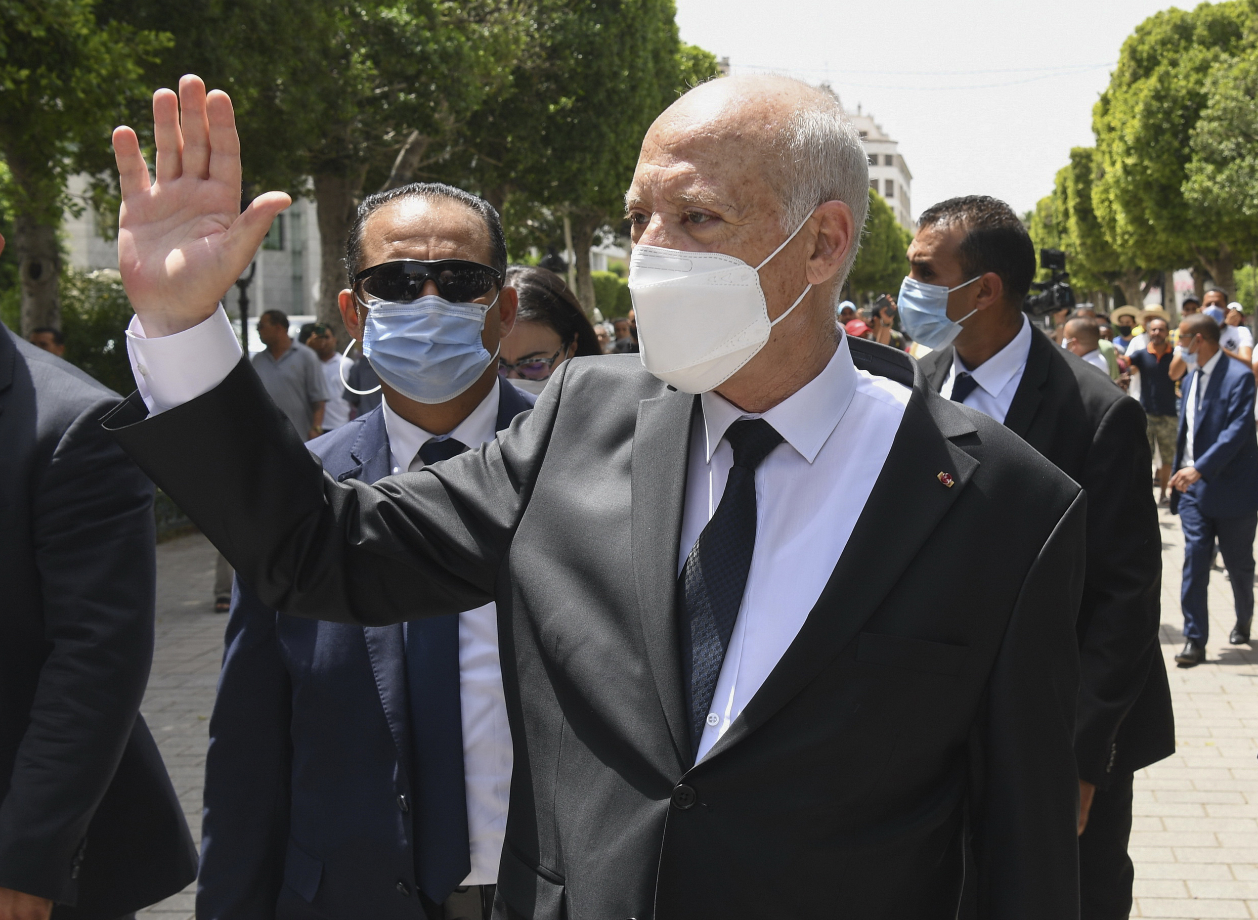 Tunisian President Kais Saied waves to bystanders as he walks along Avenue Bourguiba in Tunis, Tunisia, Aug. 1. (Slim Abid/Tunisian Presidency via AP)