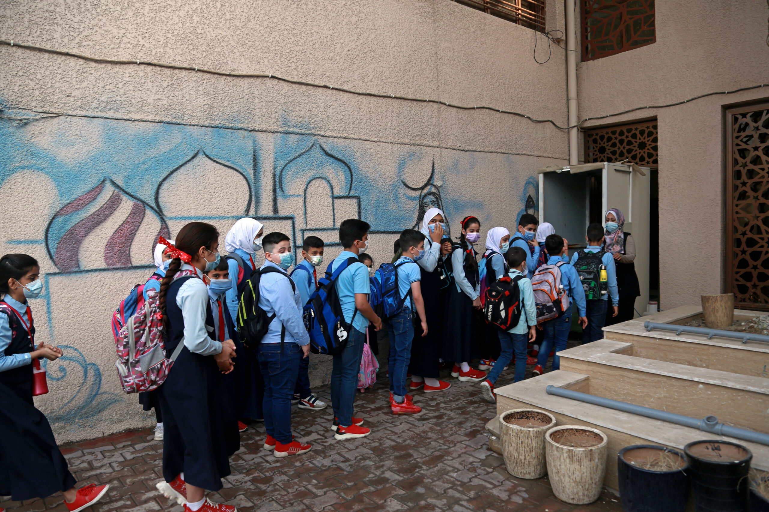 Students wearing face masks line up to enter school, Baghdad, Iraq, Nov. 1, 2021. (AP Photo/Hadi Mizban)