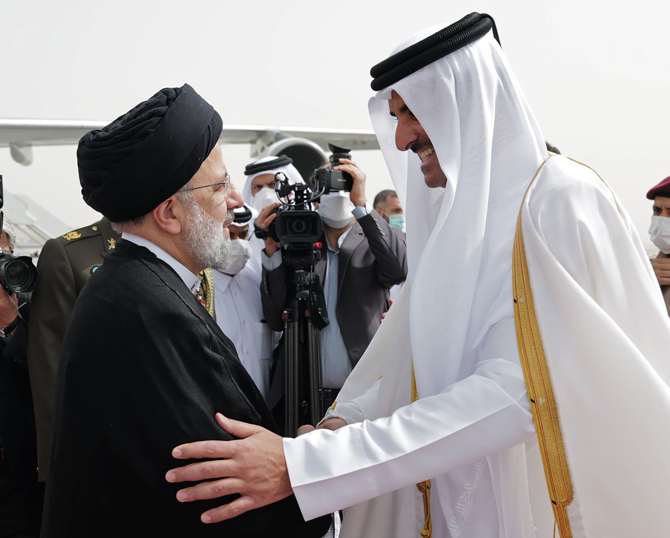 Iranian President Ebrahim Raisi, left, is welcomed by Qatari Emir Tamim bin Hamad al-Thani, as he arrives in Doha, Qatar, Feb. 21. (Qatar News Agency via AP)