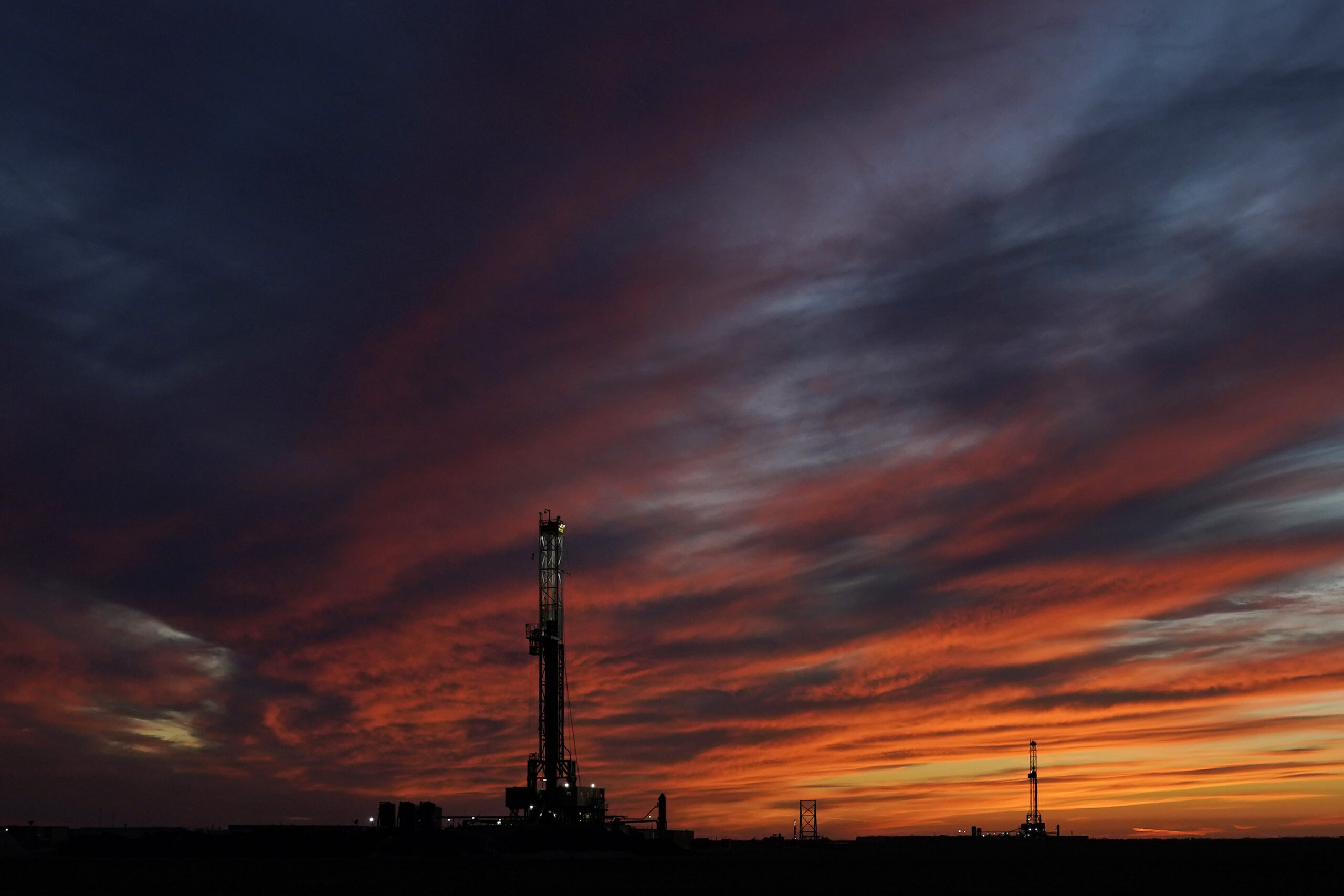 Oil drilling rigs are pictured at sunset, March 7, in El Reno, Oklahoma. (AP Photo/Sue Ogrocki)