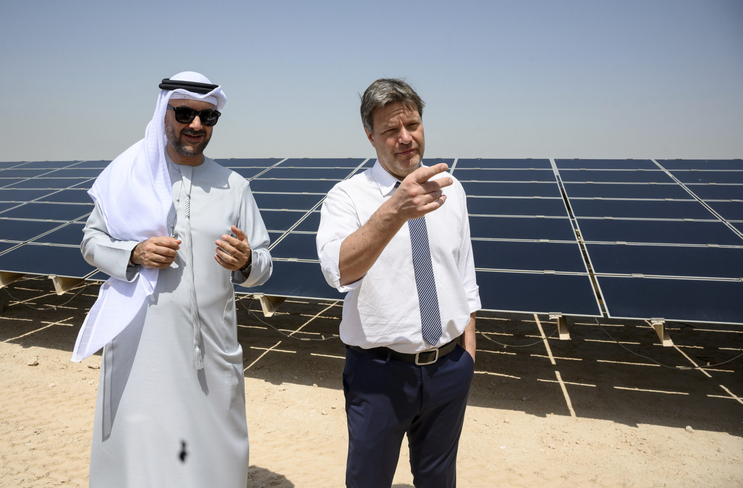 Robert Habeck, German federal minister for economic affairs and climate protection, right, and Mohammad Abdelqader El Ramahi, director of asset management and technical service at Masdar, visit a large-scale solar installation near the sustainable urban development project Masdar City, Abu Dhabi, United Arab Emirates, March 21. (Photo by: Bernd von Jutrczenka/picture-alliance/dpa/AP Images)