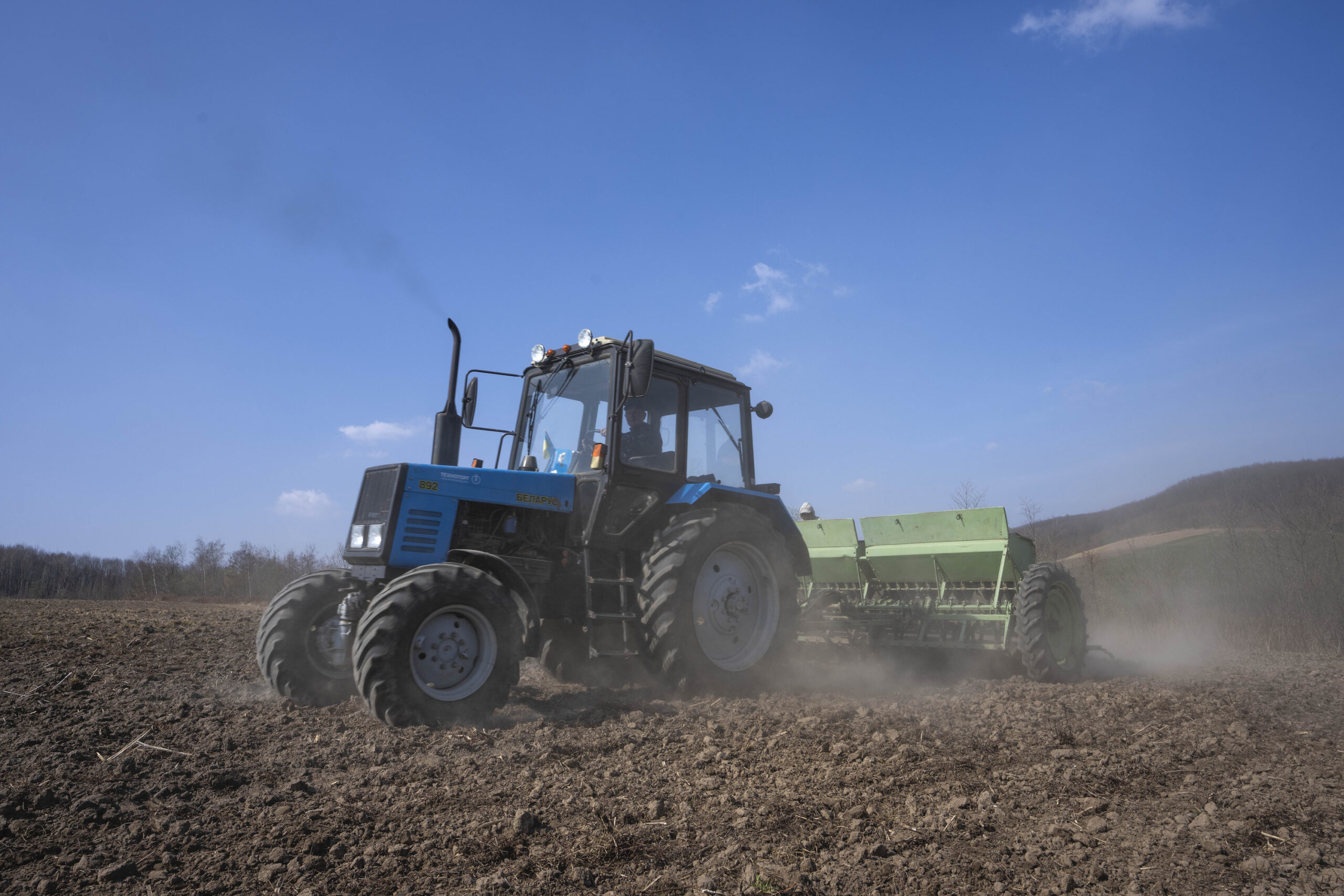 Workers plow wheat in western Ukraine, March 26, 2022. (AP Photo/Nariman El-Mofty)