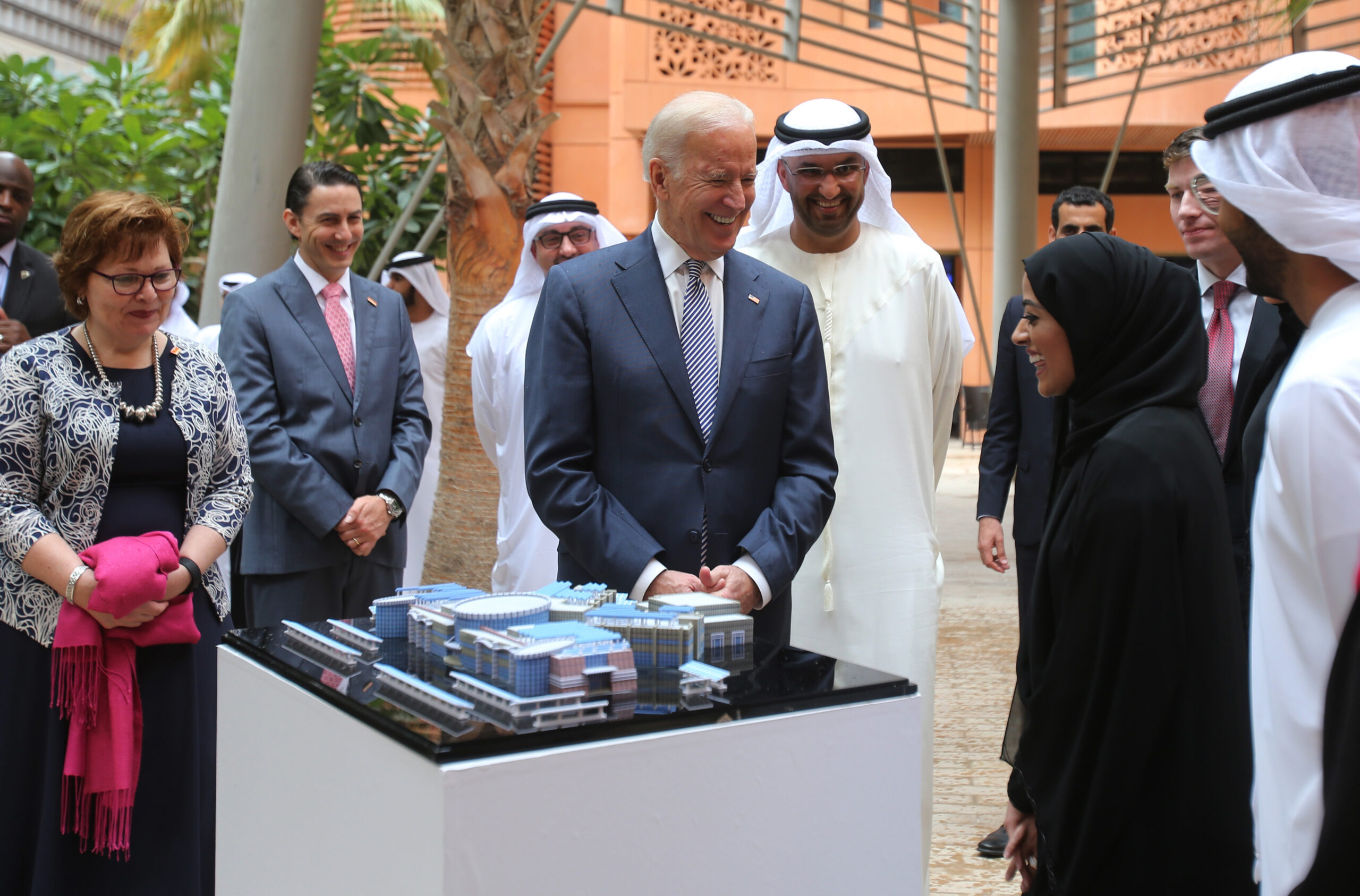 Joseph R. Biden Jr., then-U.S. Vice President, center, laughs with one of the Masdar City employees as Sultan Al Jaber, UAE minister of state and chairman of Masdar City, behind him on right, looks on during his first day tour in Abu Dhabi, United Arab Emirates, March 7, 2016. (AP Photo/Kamran Jebreili)