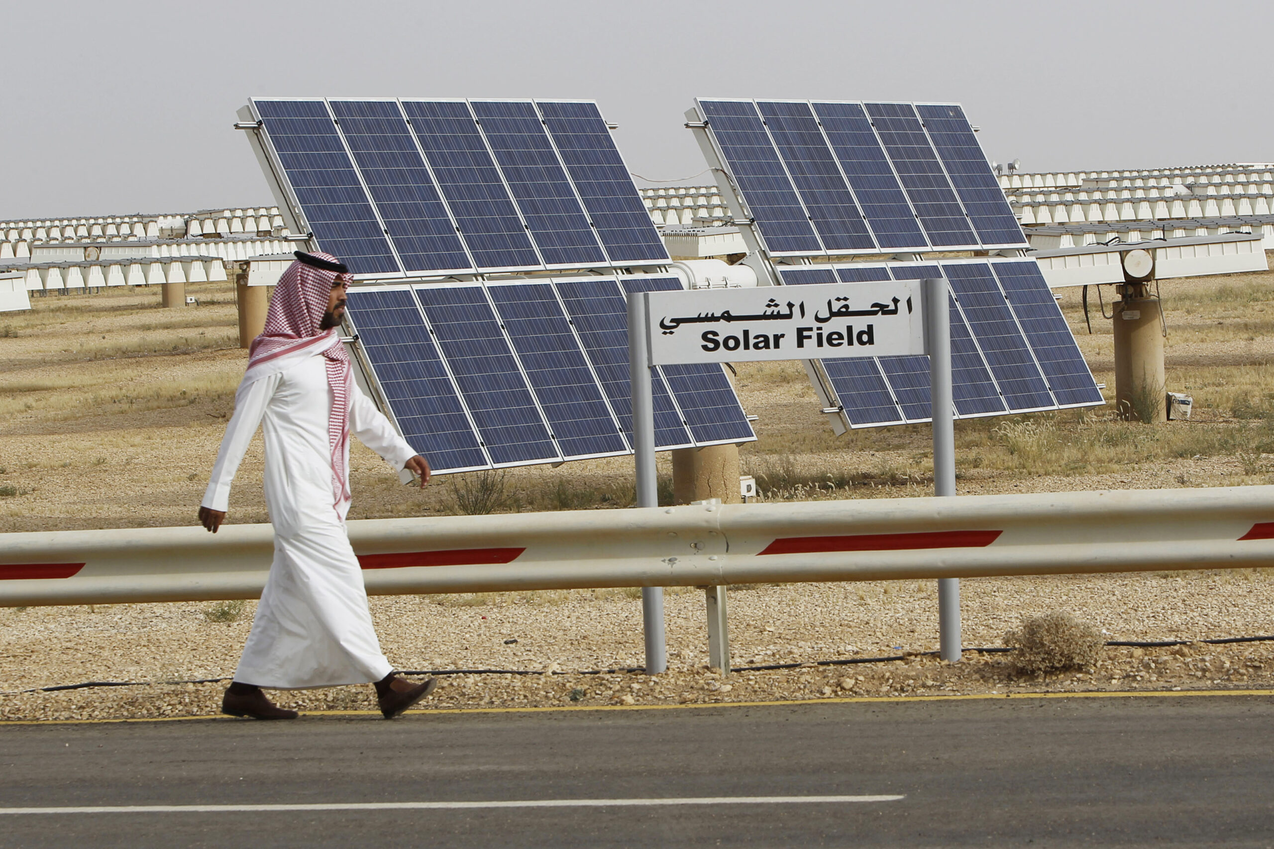 A Saudi man walks on a street past a field of solar panels at the King Abdulaziz City for Science and Technology, Al-Oyeynah Research Station, May 21, 2012. (SAUDI-SOLAR/ REUTERS/Fahad Shadeed)